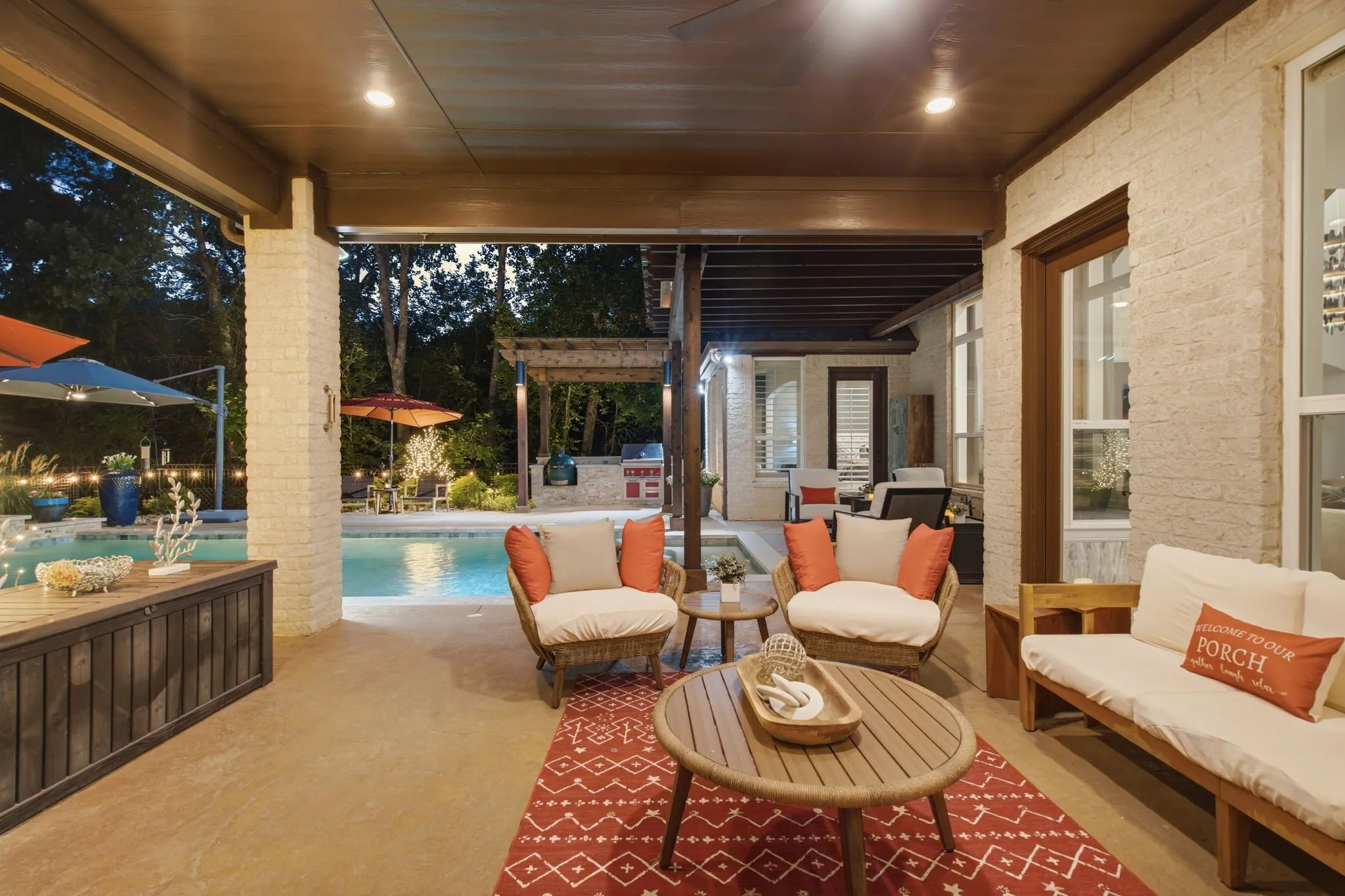 Outdoor living takes center stage with an expansive covered patio designed as a true extension of the home. Multiple conversation and dining areas surround the pool, while the combination of covered spaces, open-air patios, mature trees and ambient landscape lighting creates an exceptional setting for entertaining year-round. With room to gather, dine, grill, swim or simply relax, this backyard offers the kind of resort-inspired lifestyle that makes staying home feel like a getaway. Notice the Hestan grill and Green Egg in the background!