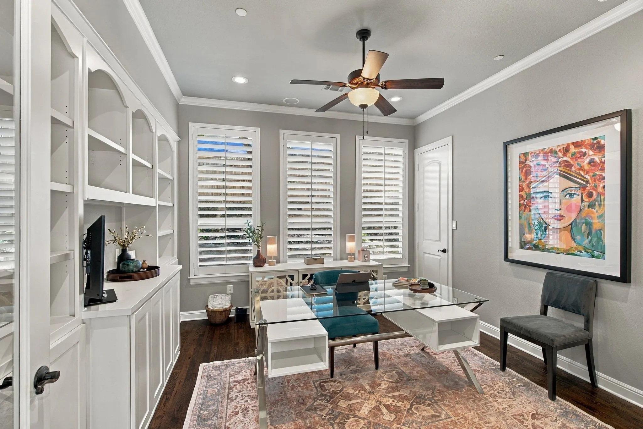 A polished private home office combines style and function with French doors, extensive custom built-ins and a dedicated closet. Rich hardwood floors, plantation shutters and abundant natural light create an inviting workspace, while the closet adds valuable storage and flexibility for future use.