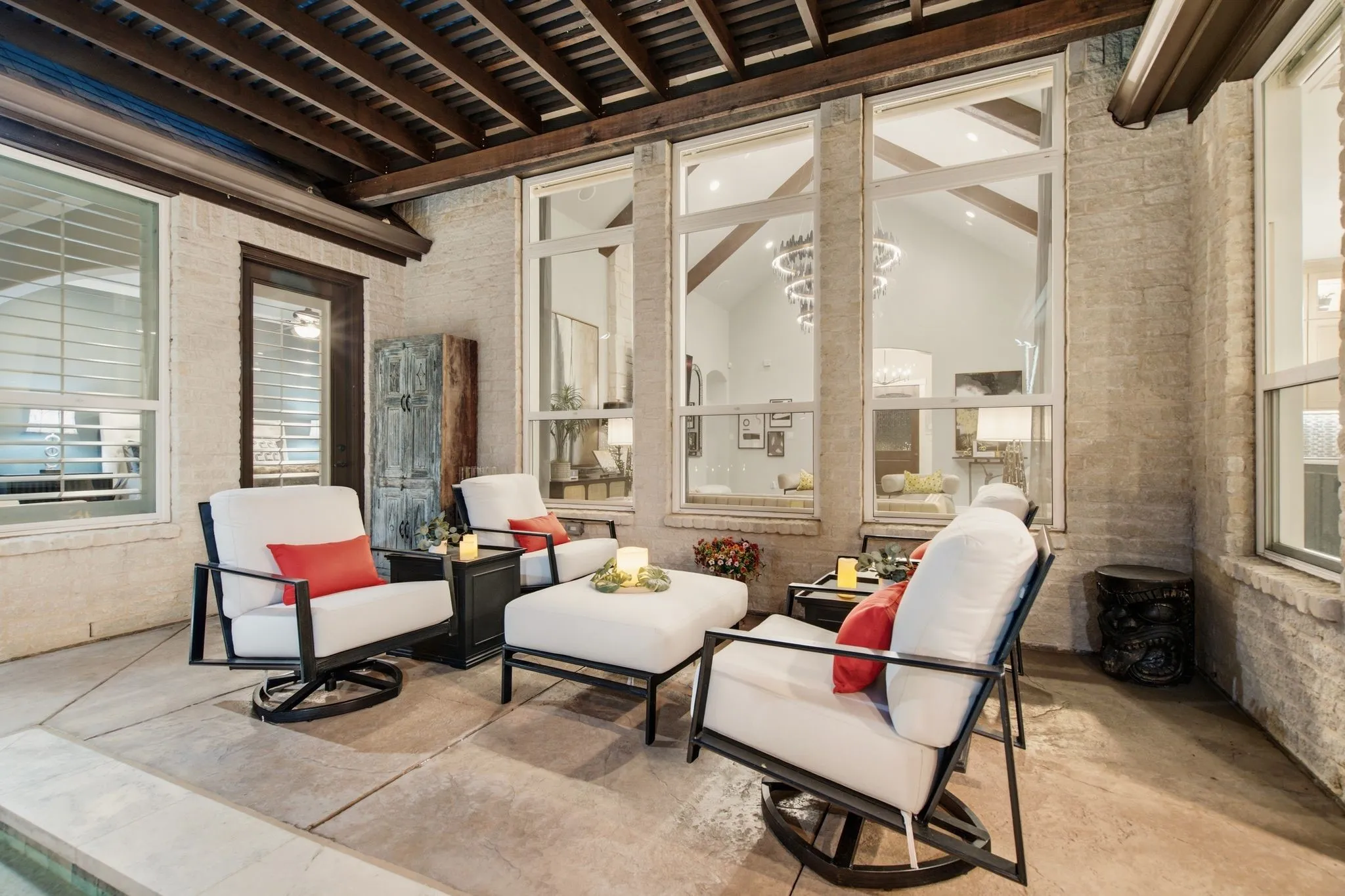 An outdoor living room in every sense—this beautifully sheltered gathering space is framed by substantial wood beams, a pergola-style ceiling and light brick, creating an intimate retreat just steps from the pool. Soaring windows provide a dramatic view into the home’s vaulted living room while filling the interior with natural light, beautifully connecting indoor and outdoor living. Comfortable, private and designed for lingering, it’s an exceptional setting for morning coffee, conversation with friends or relaxing poolside at the end of the day.