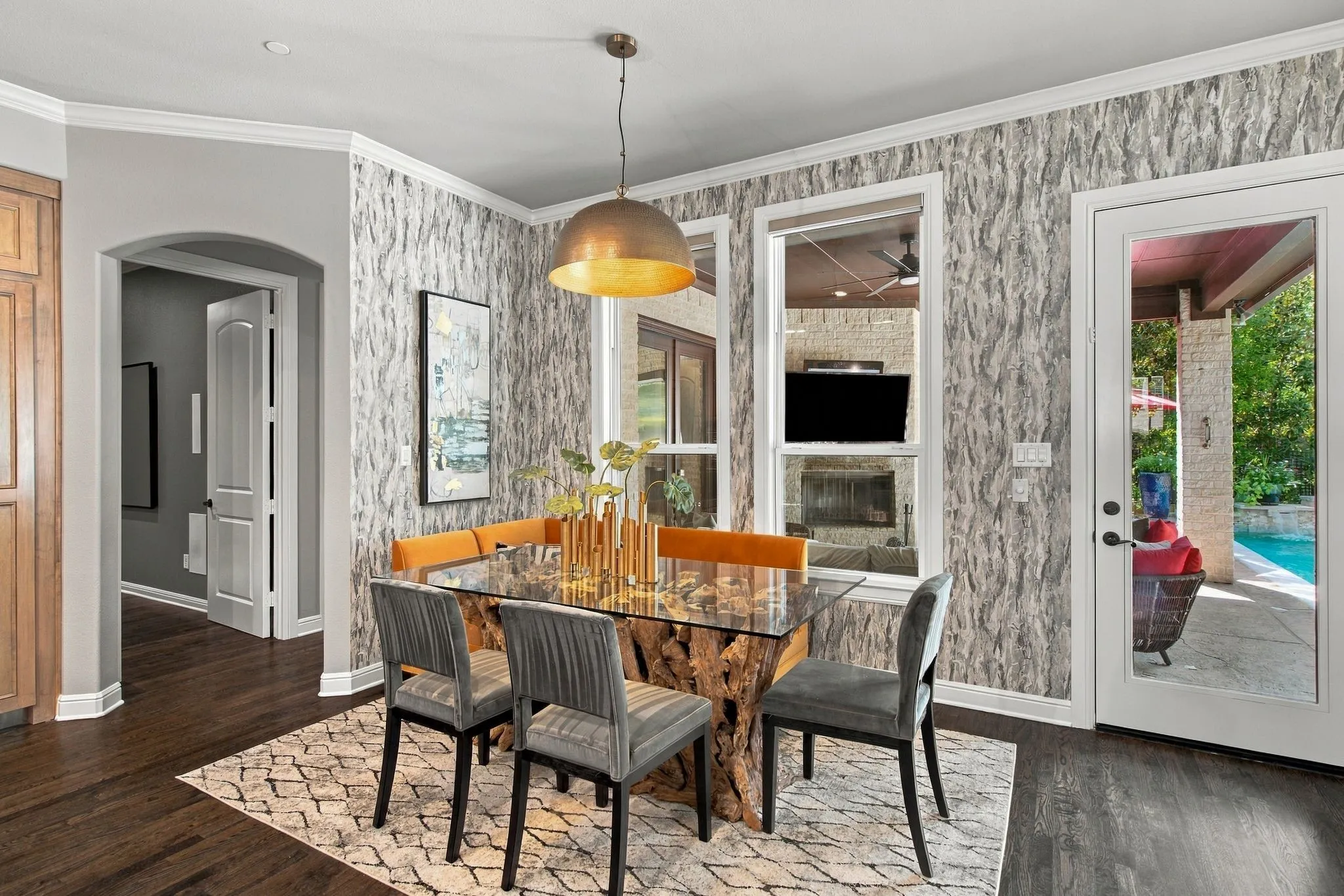 Wood-finish flooring with a decorative area rug, arched doorway, and built-in cabinetry
