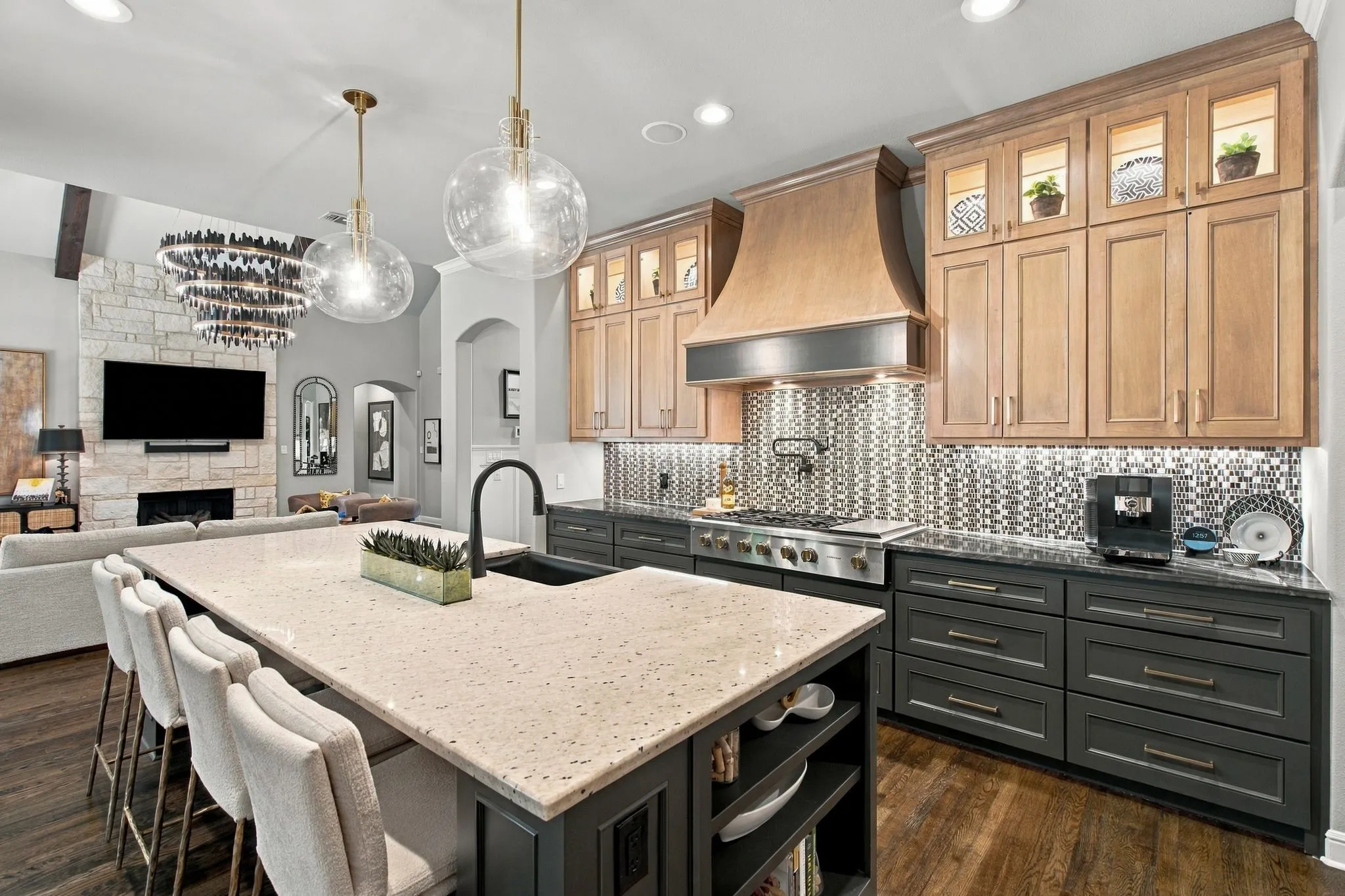 A true showpiece, this chef-inspired kitchen pairs high-end style with exceptional function. The oversized entertaining island provides abundant seating and prep space, while ceiling-height custom cabinetry, a dramatic statement range hood, professional-style gas range, designer lighting and richly contrasting finishes create an unforgettable look. Open to the soaring great room, this beautifully designed kitchen delivers the open-concept luxury today’s buyers are searching for.