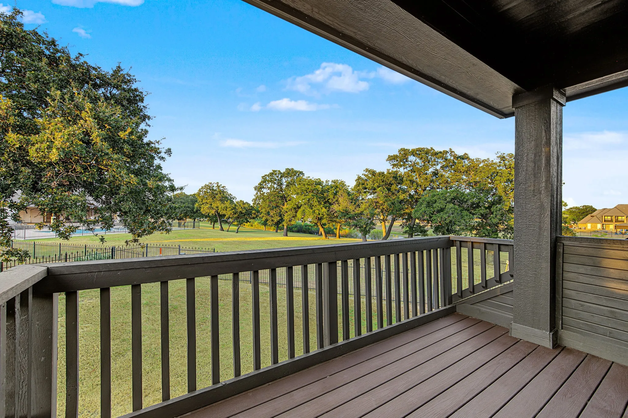 Covered outdoor balcony featuring composite decking and painted railings