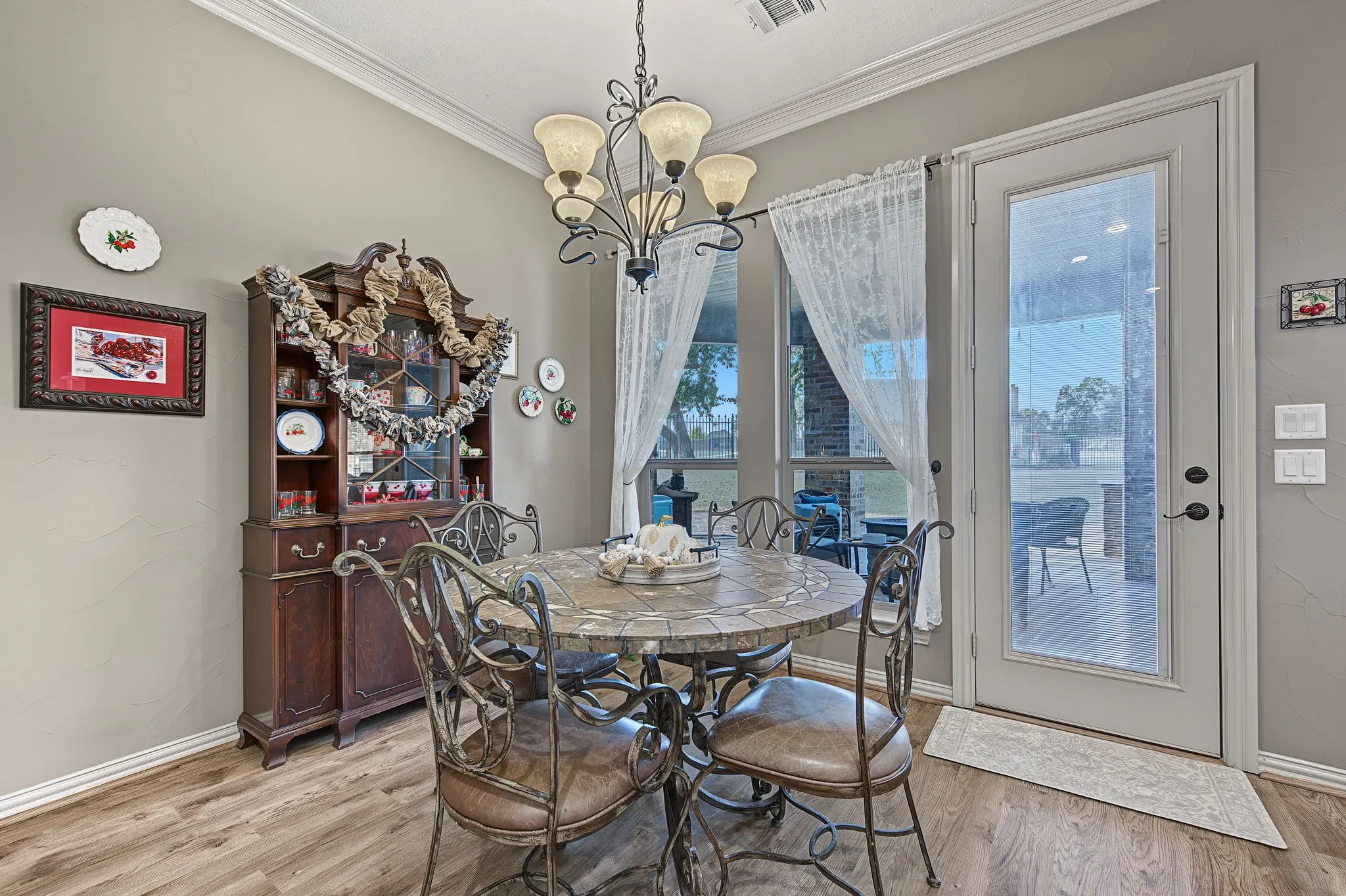 Wood-finish flooring, crown molding, and a full-light glass door leading to an outdoor area