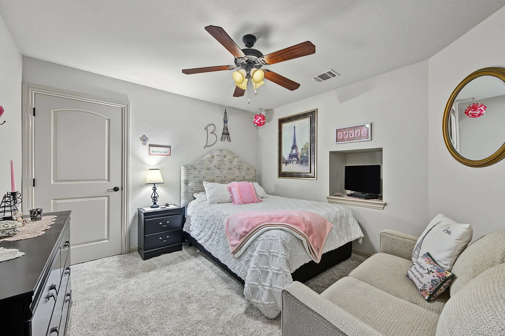 Upstairs bedroom with ceiling fan with light fixture, carpet flooring, arched interior door