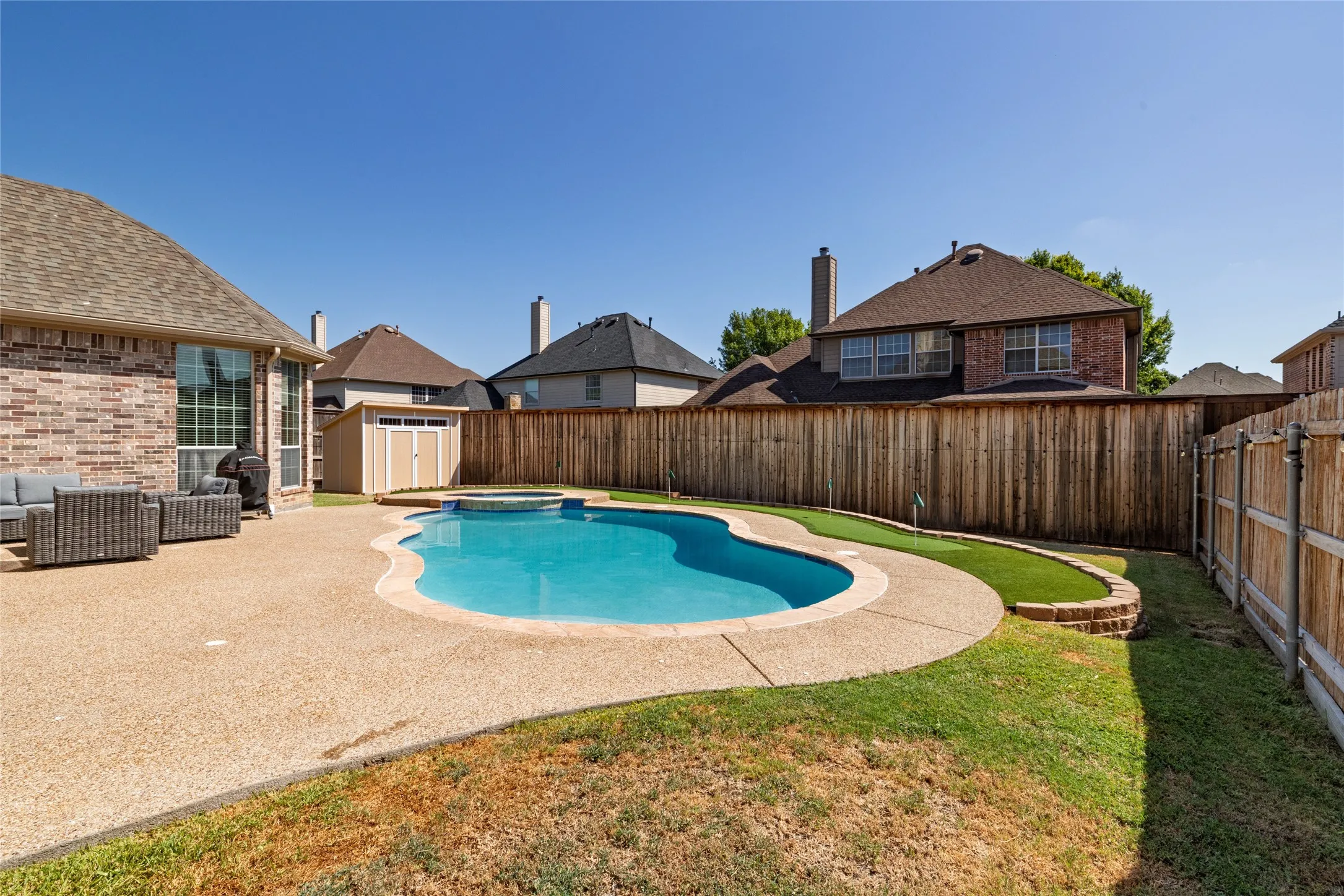 View of pool, spa, and shed