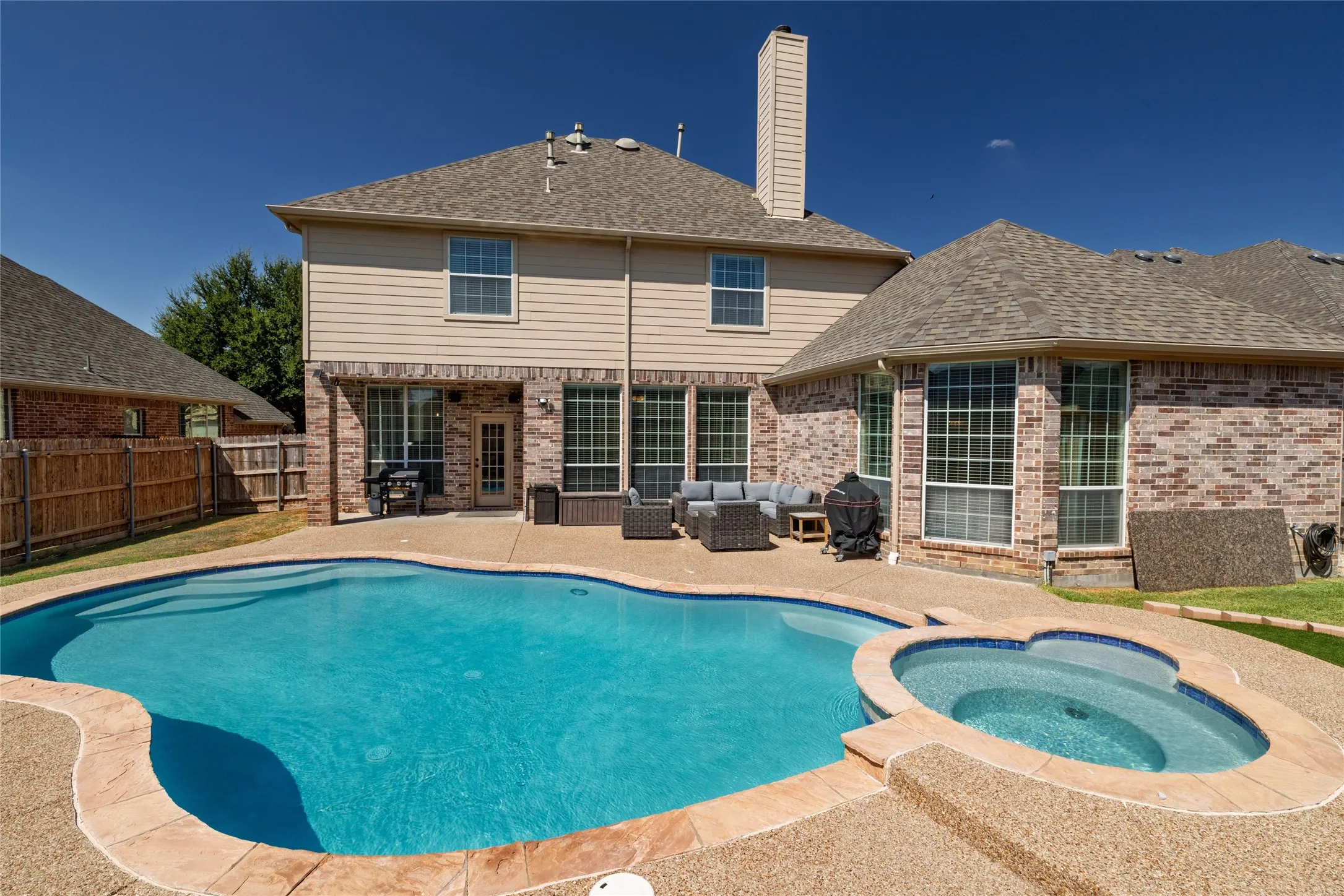 View of back of house and pool/spa