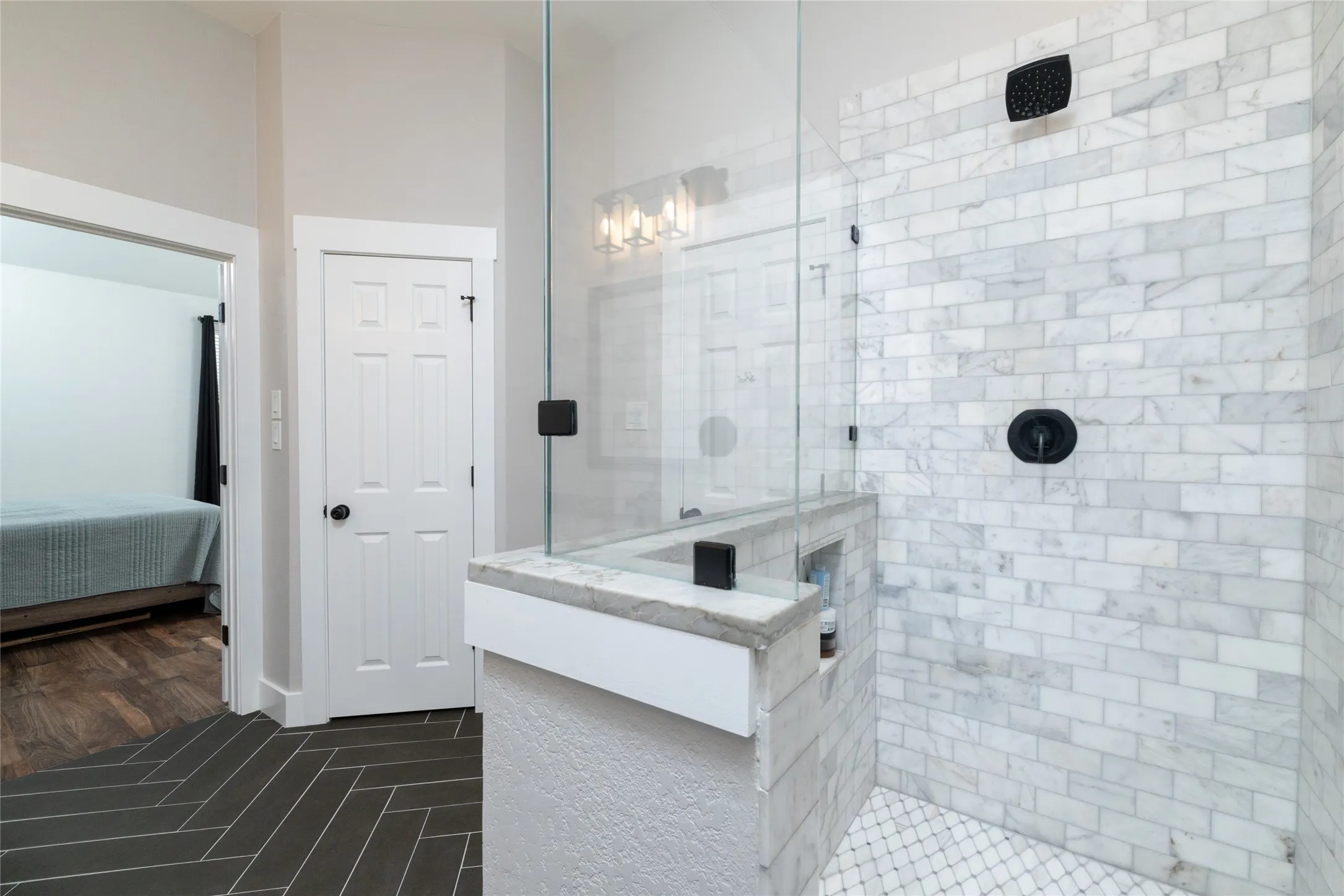 Primary bathroom walk in shower, walk in closet entrance, and toilet area