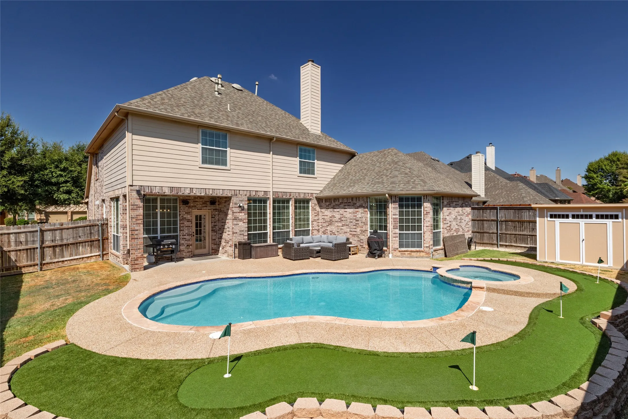 Back of house with view of turf putting green