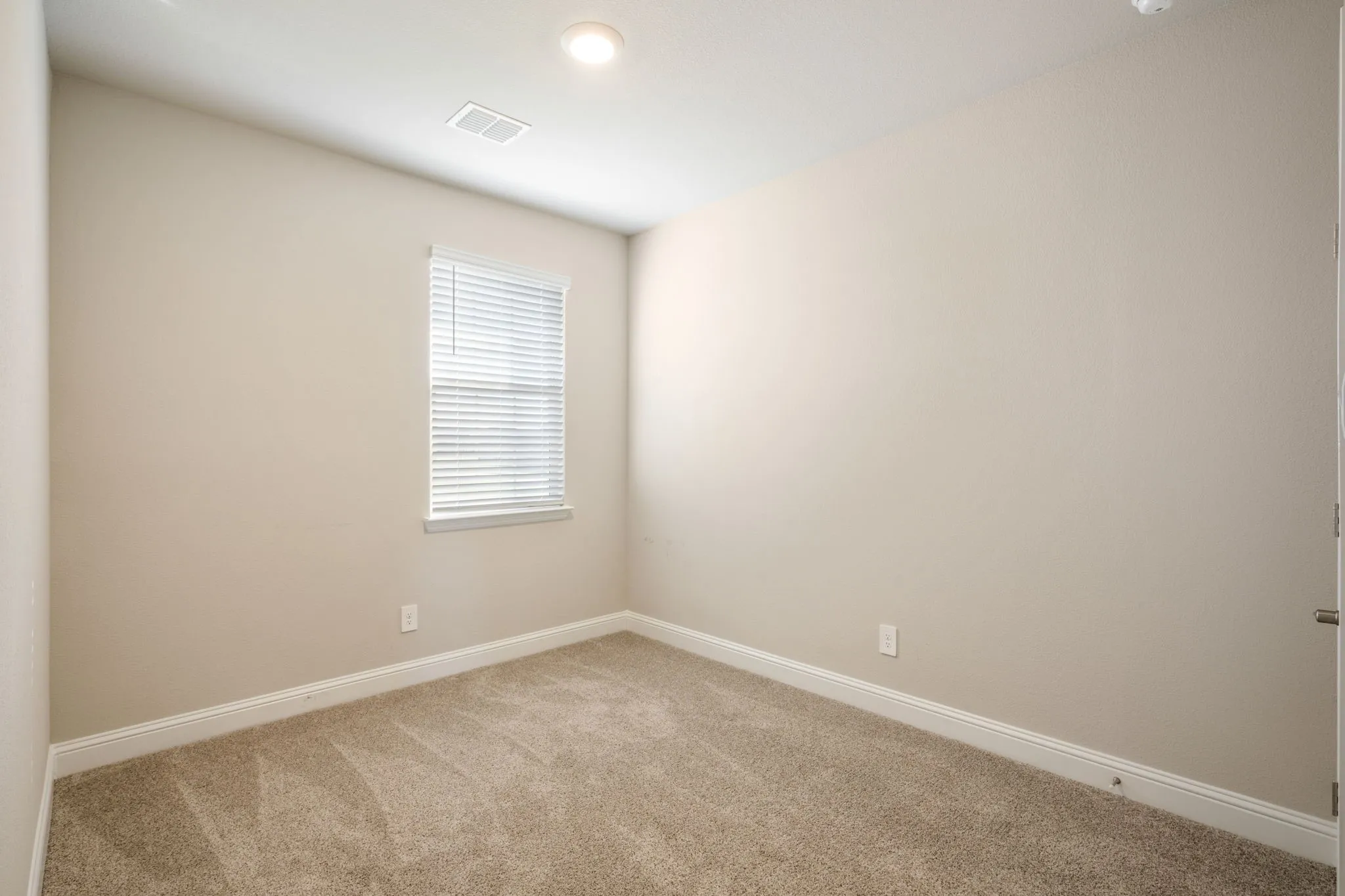Neutral tone wall paint, recessed lighting, window with blinds, and carpeted flooring