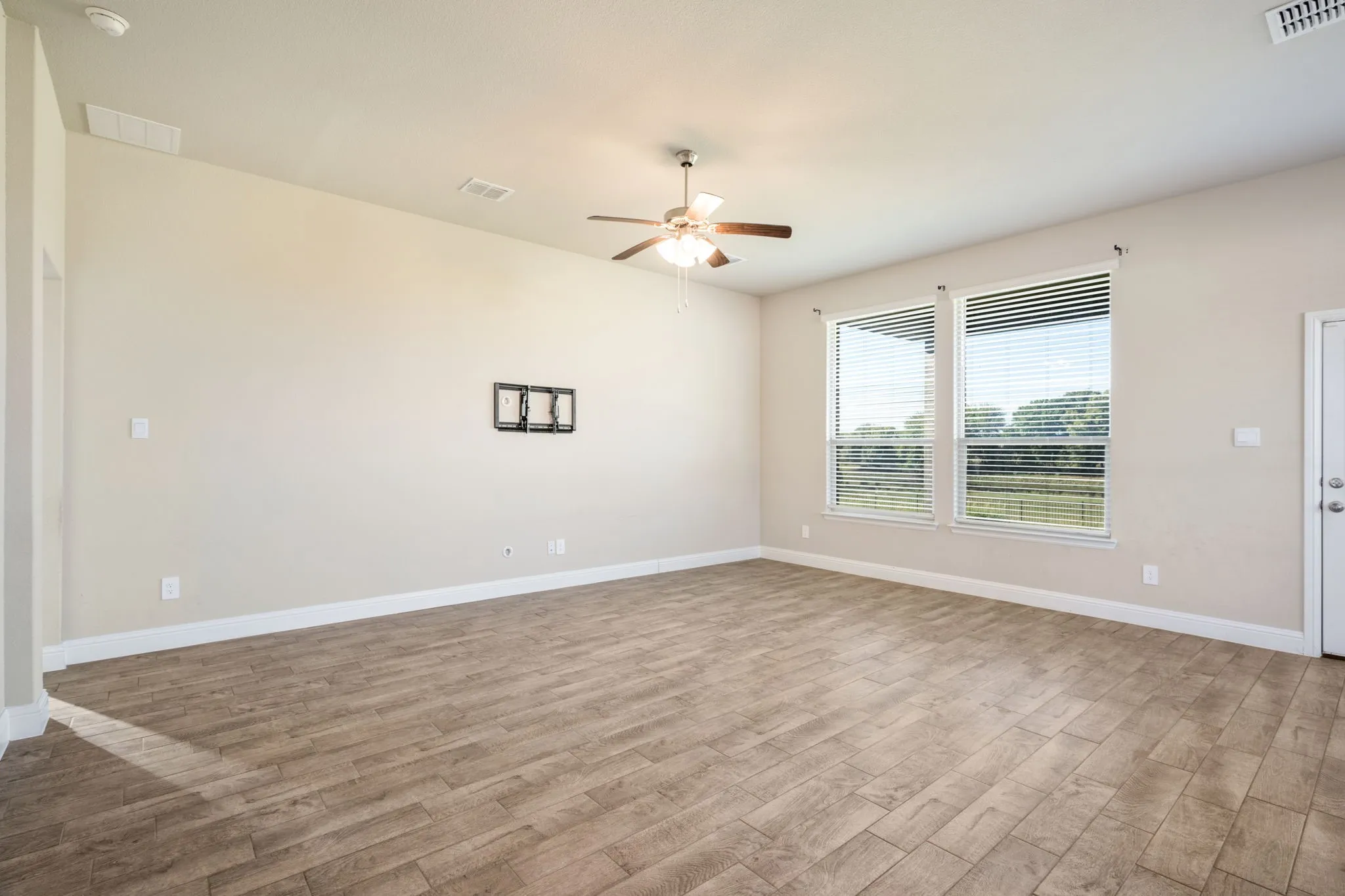 Wood-finish tile flooring throughout, ceiling fan with integrated lighting, and dual windows