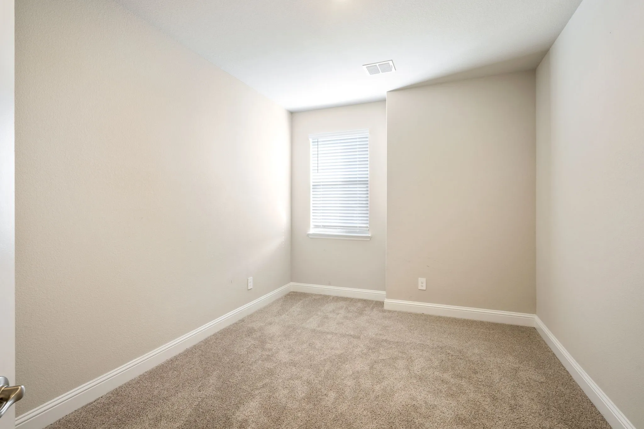 Neutral-toned walls complement plush carpet flooring