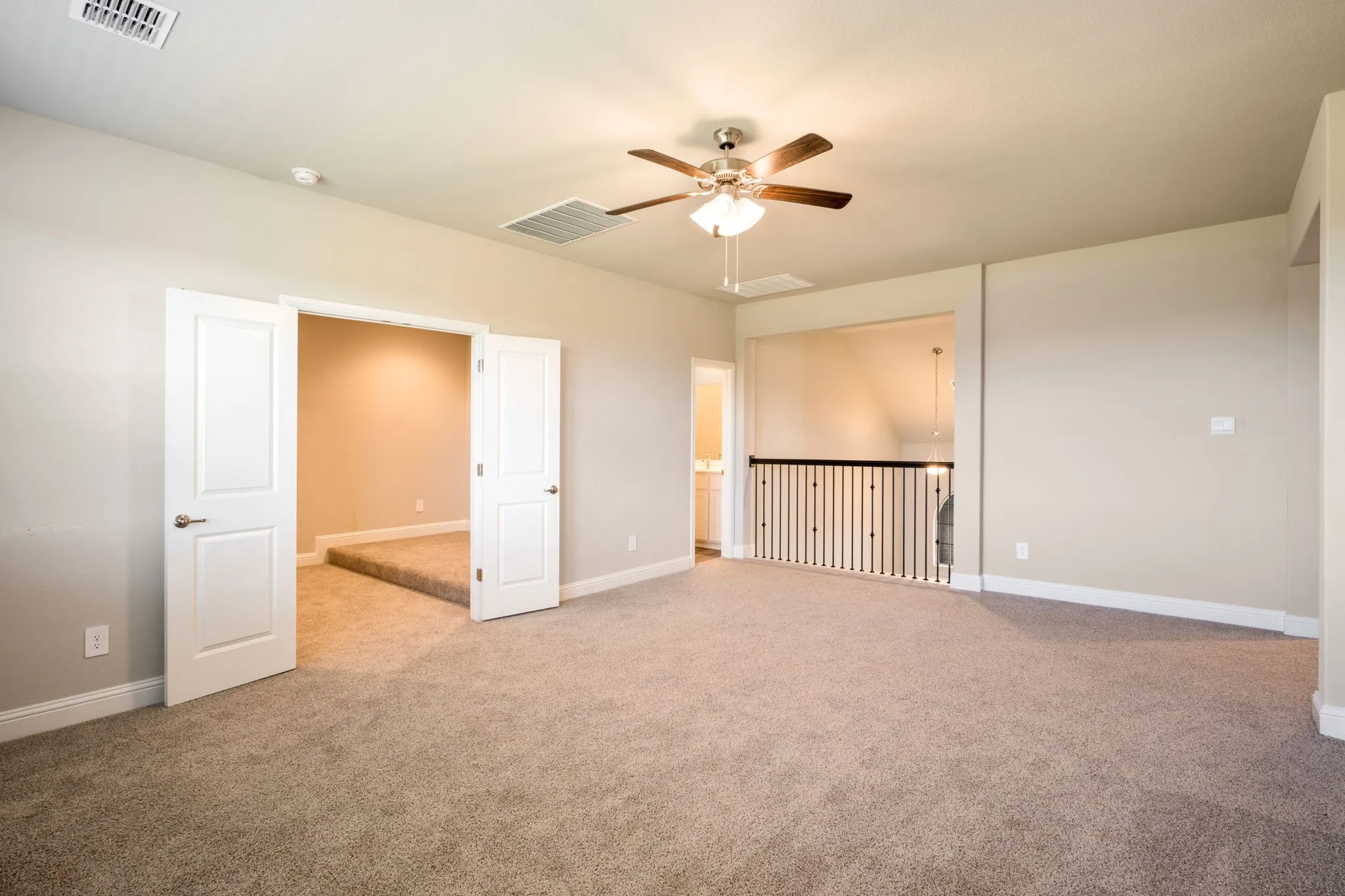 Carpeted floor, wood-finish ceiling fan, double entry doors, open railing, and neutral wall tones