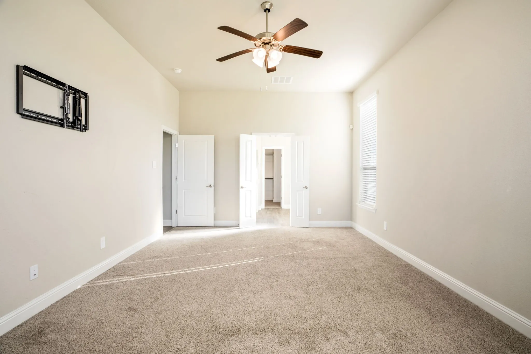 Neutral-toned carpeting, ceiling fan with integrated lighting, window with blinds, recessed lighting, and a built-in wall mount