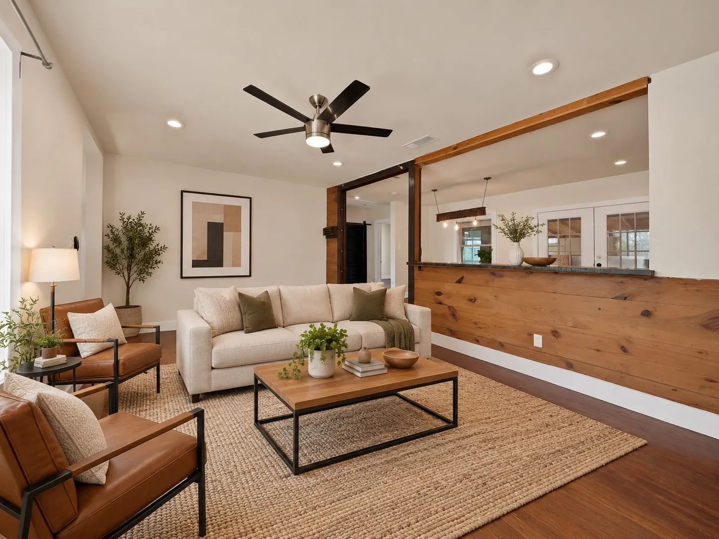 virtually staged Living room: Open concept layout with knotty pine plank breakfast bar, exposed wood beam header, and dark timber posts connecting to the dining area. Recessed lighting, ceiling fan, and hardwood floors throughout.