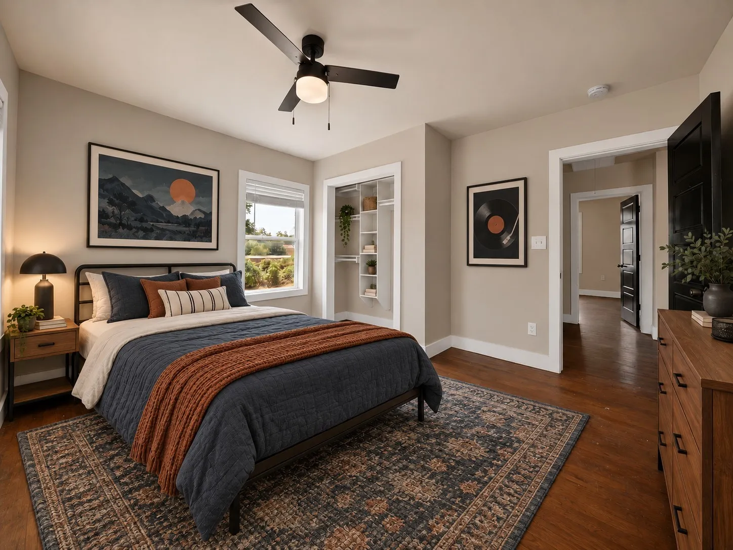 virtually staged Bedroom: Hardwood floors, ceiling fan with light, and window with natural light. Reach-in closet with built-in shelving organizer and black interior doors.