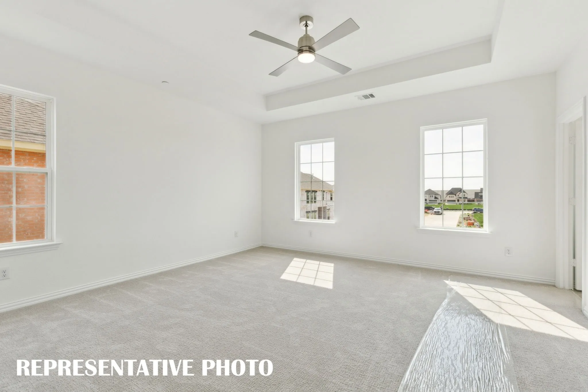 Offering high ceilings, large windows and plush carpeting, this owner's bedroom is a peaceful retreat where you can relax and renew.  REPRESENTATIVE PHOTO