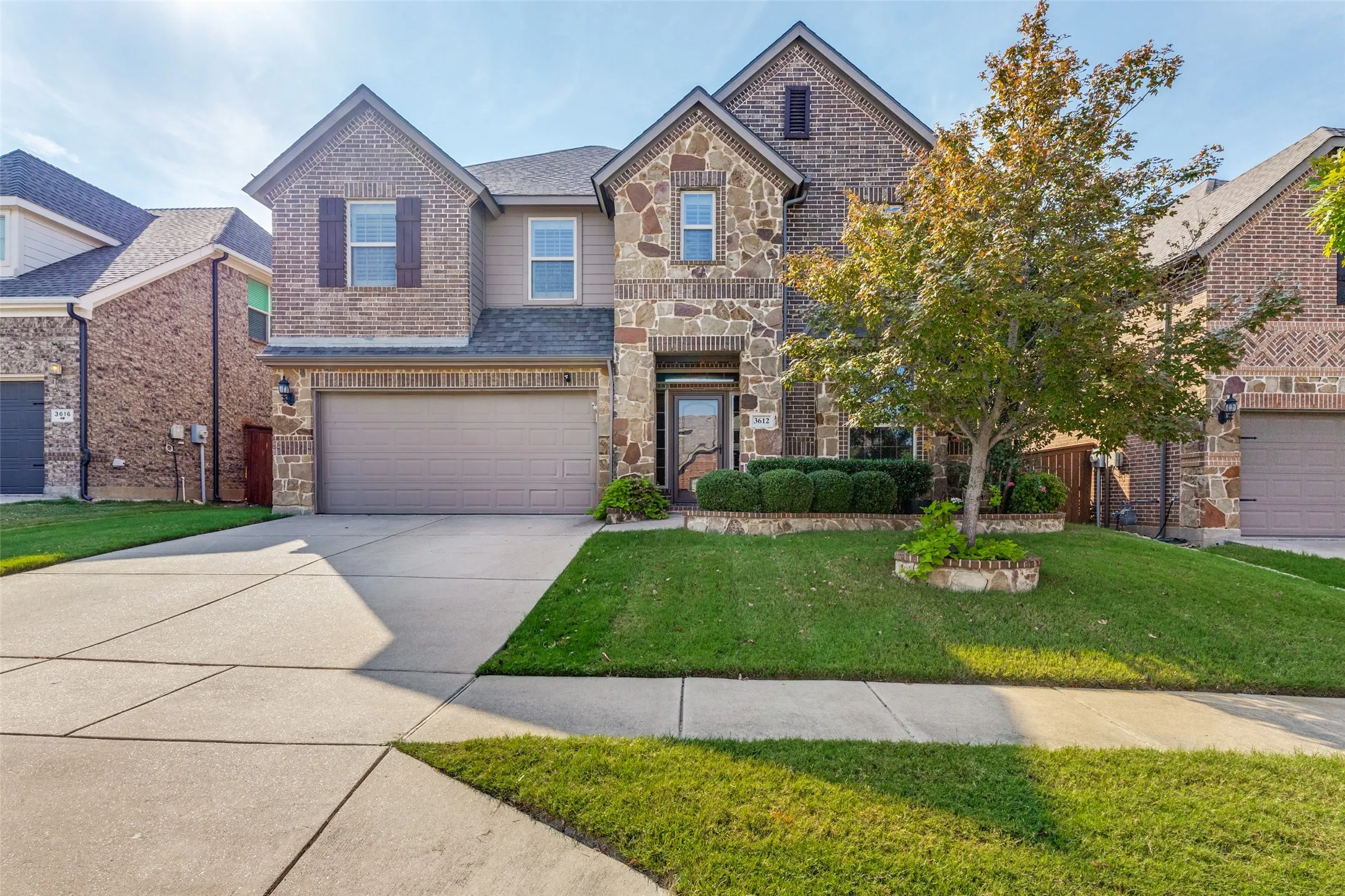 Front of home with mature tree and landscaping