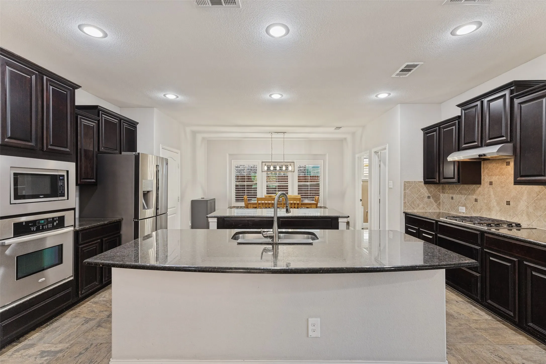 Kitchen with two large islands, recessed lighting, walk in pantry and plenty of counterspace.