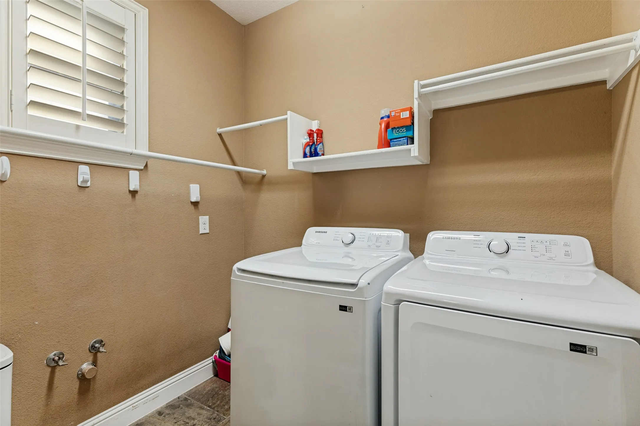 Laundry room with built in shelving and small window.