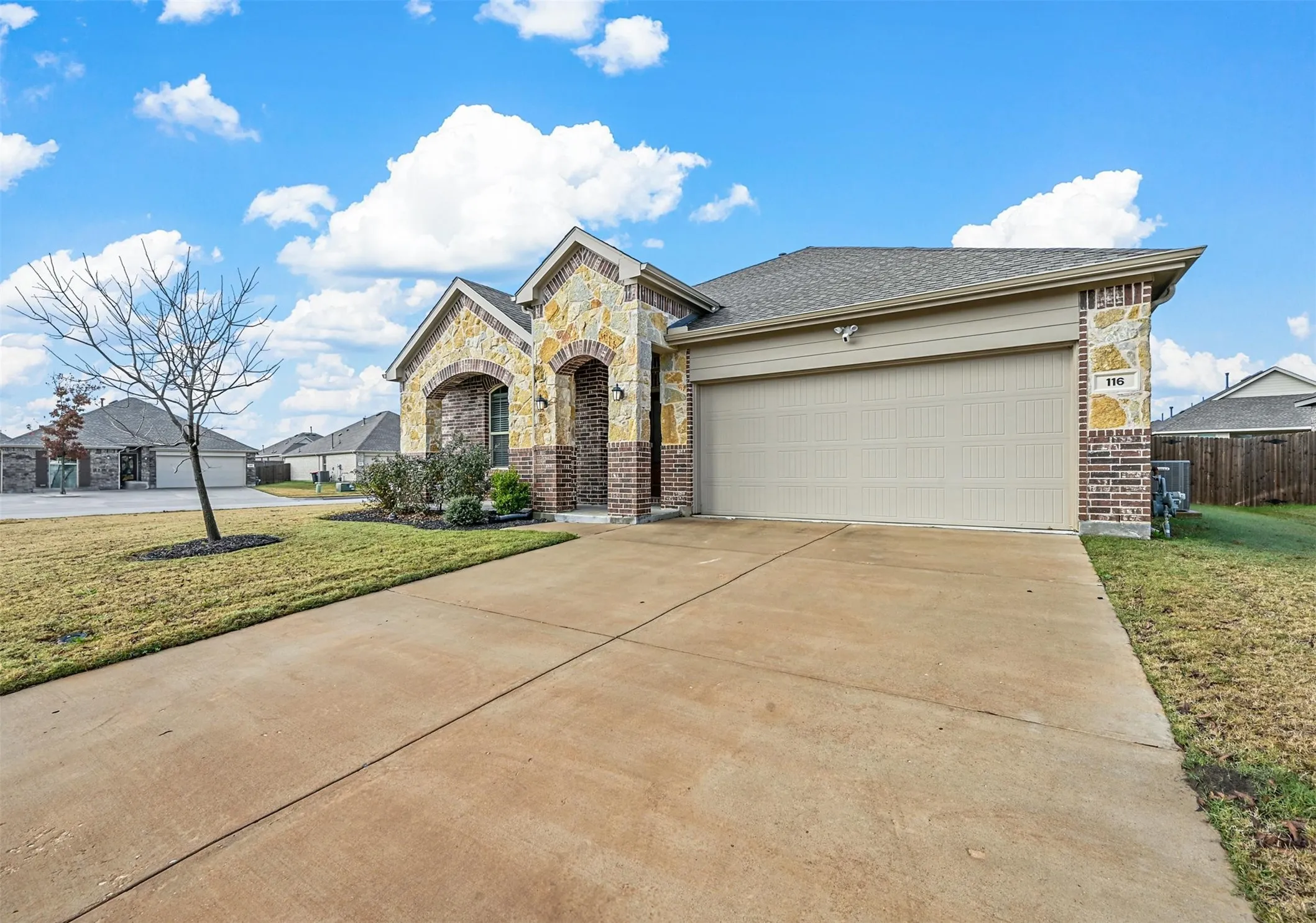 View of front facade featuring a garage and a front lawn