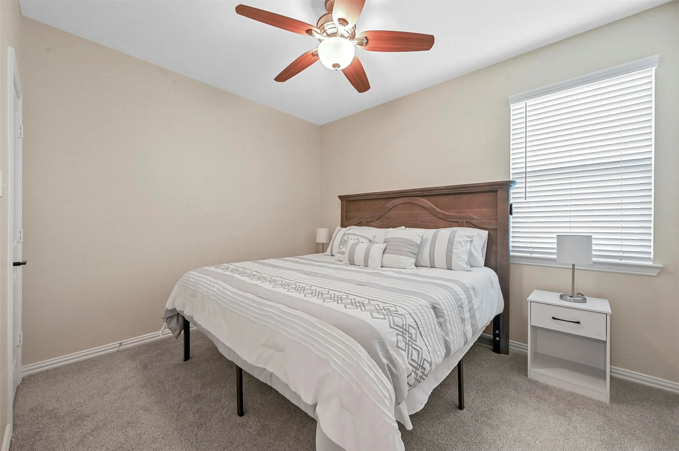 Carpeted bedroom featuring ceiling fan
