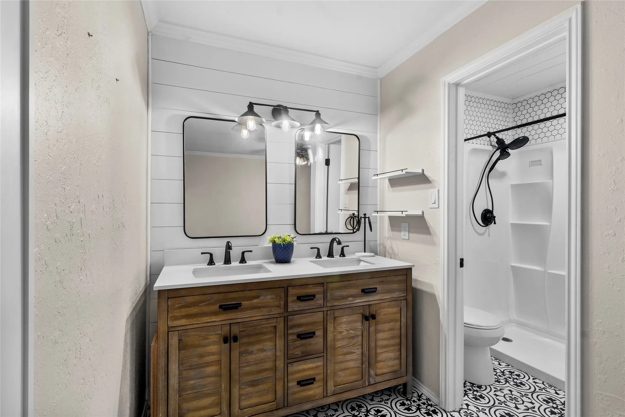 Dual vanity with white countertop, black hardware, and wood-finish cabinetry