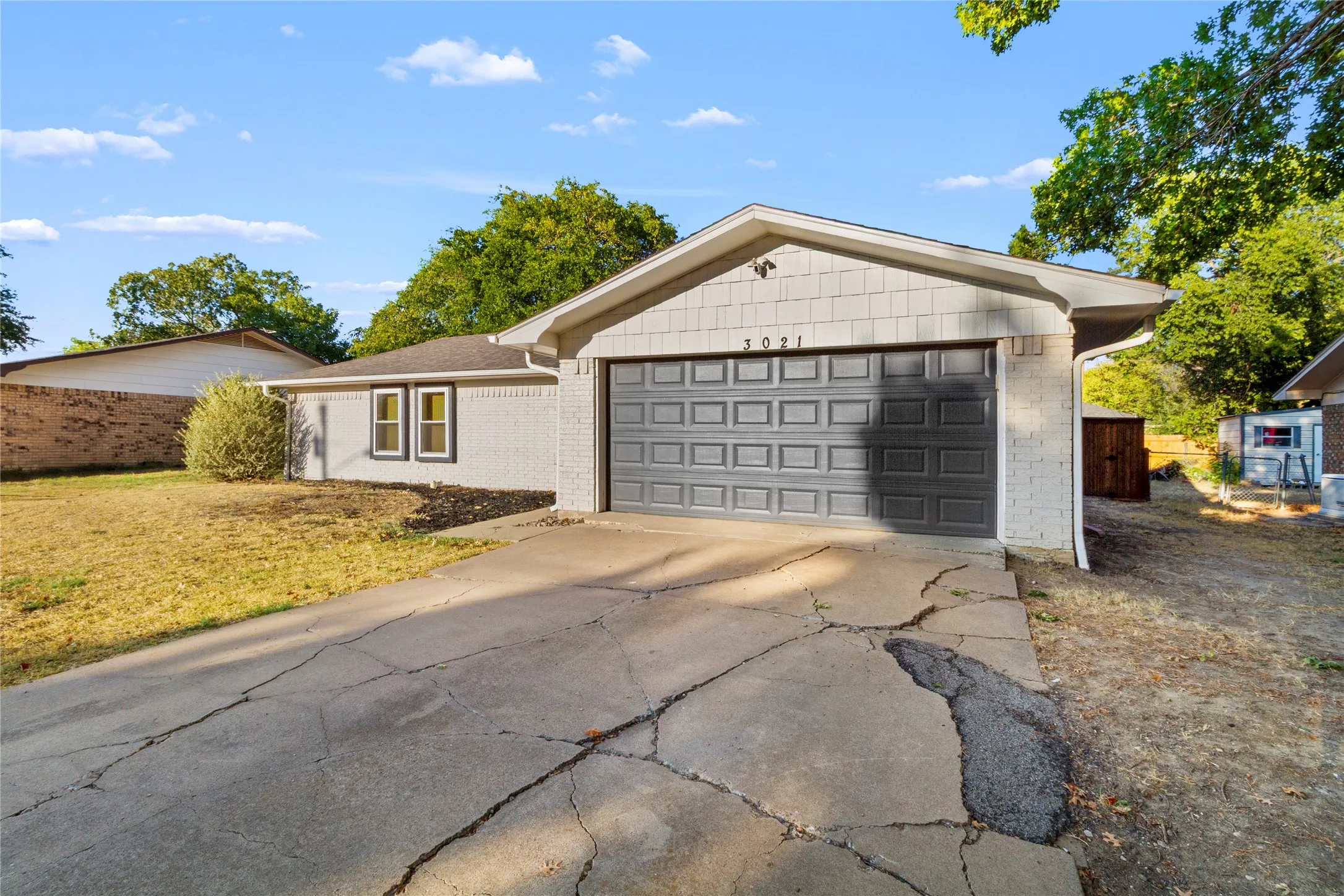 Single-story exterior featuring a gray brick facade and a multi-panel garage door