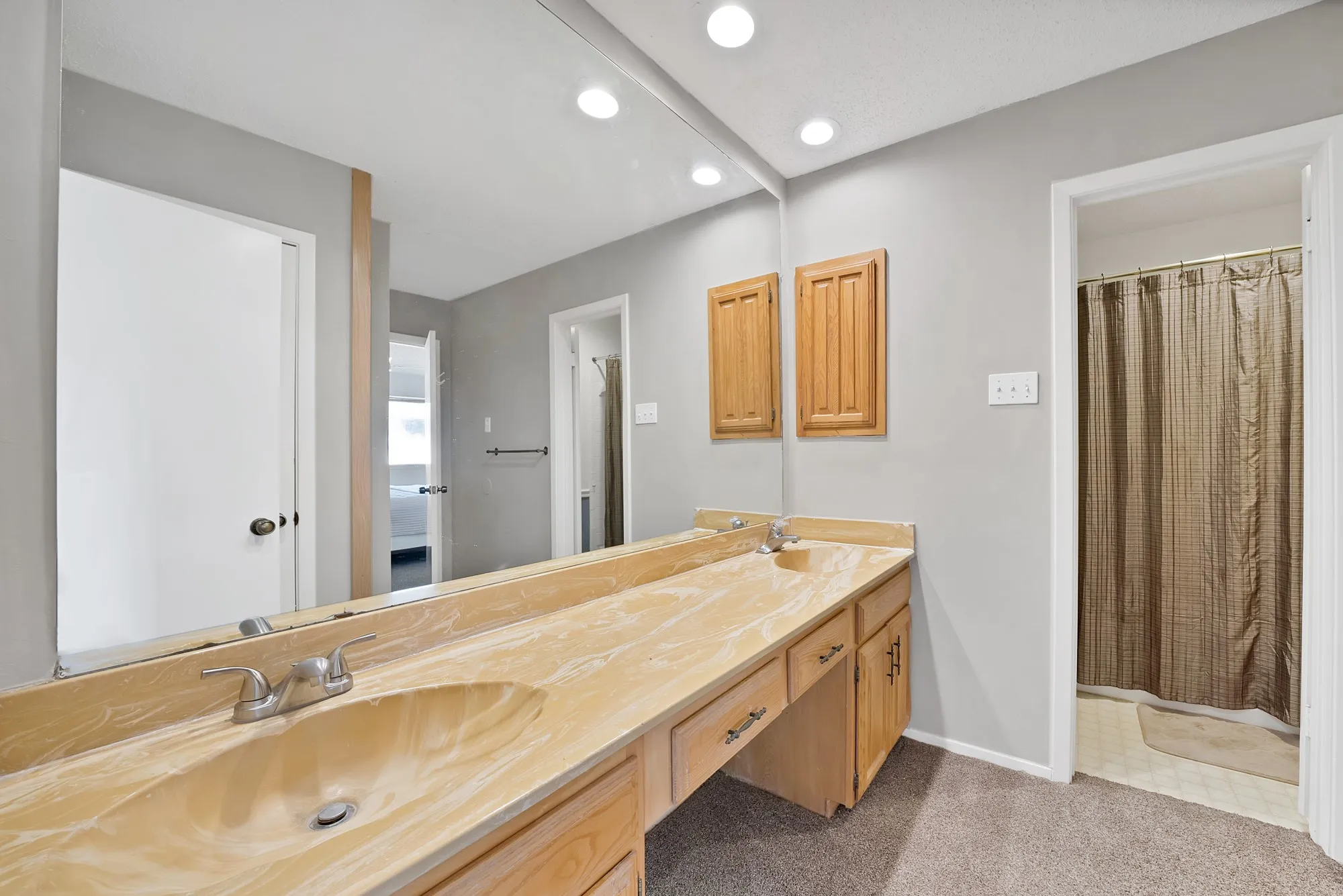 Double vanity with integrated sinks and wood-finish cabinetry