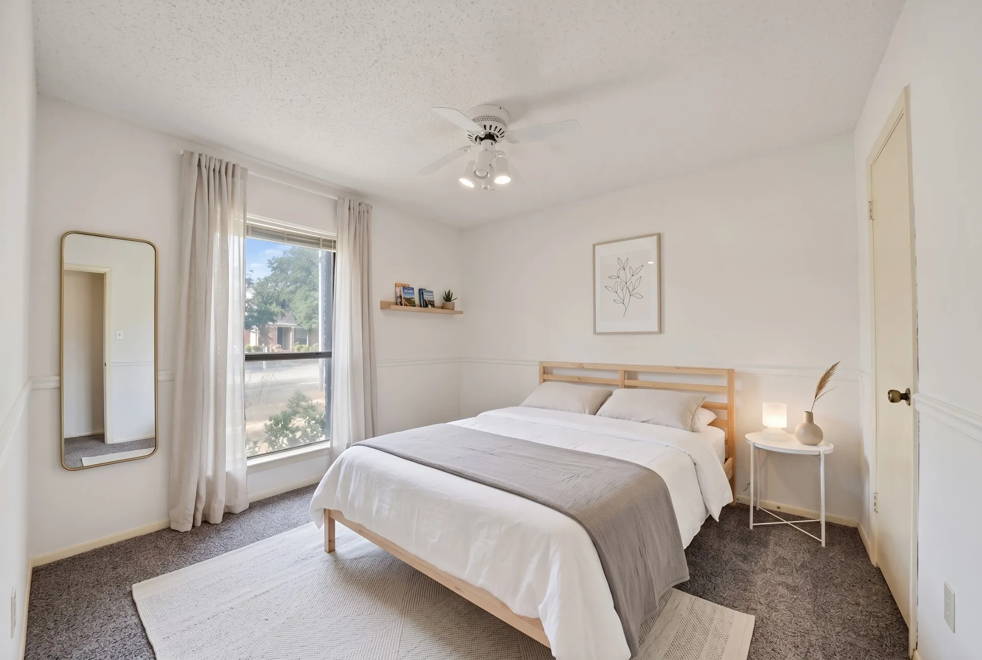 Virtually Staged Window with natural light, wall-mounted shelving, ceiling fan with integrated lighting, door with brass-finish hardware, and textured carpeting