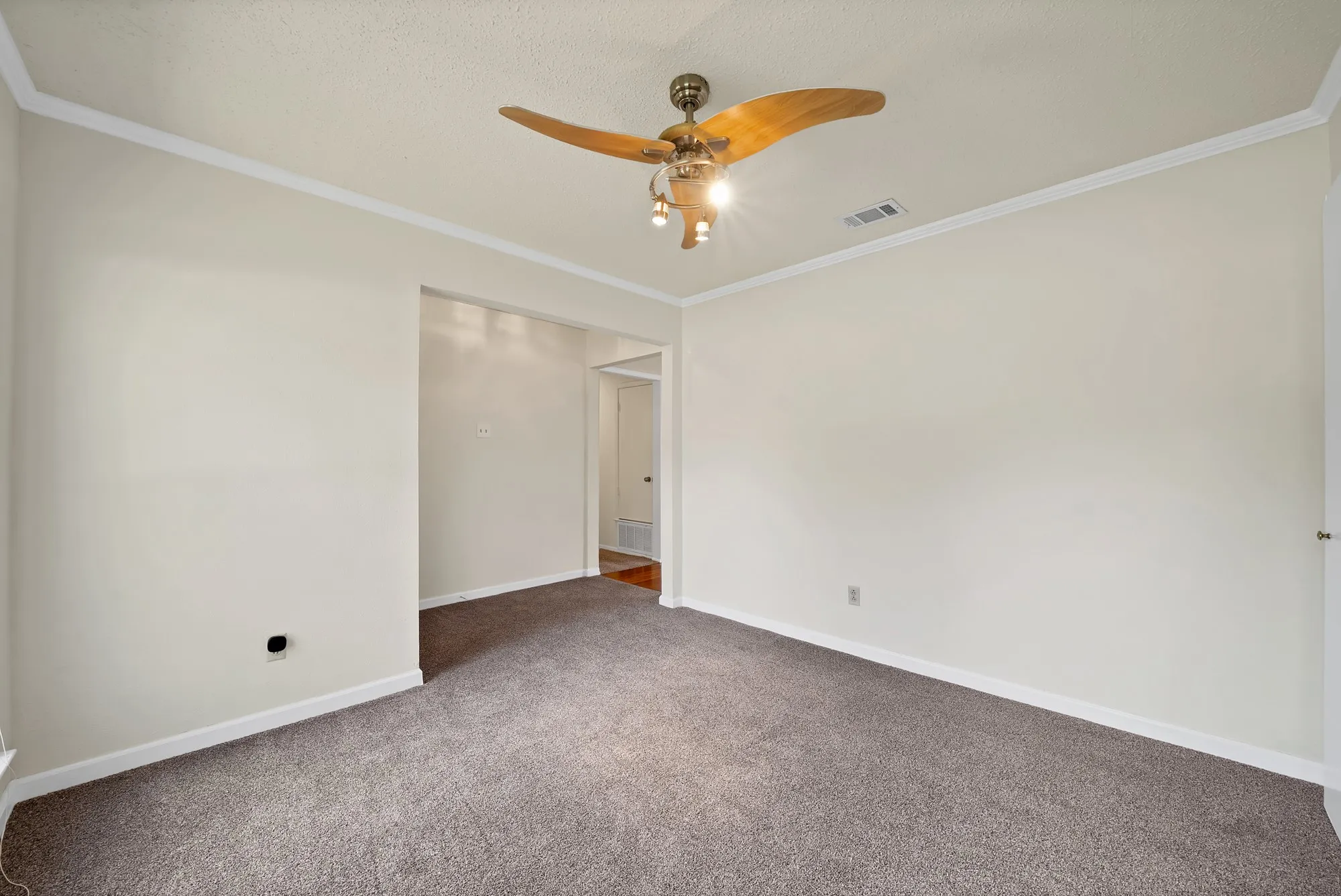 Plush carpeting with an archway, crown molding, and a ceiling fan with integrated lighting