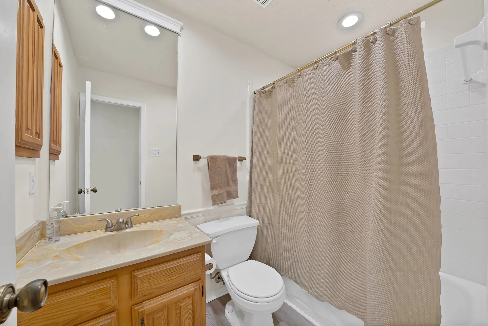 Wood-finish vanity with an integrated sink and stone-finish countertop