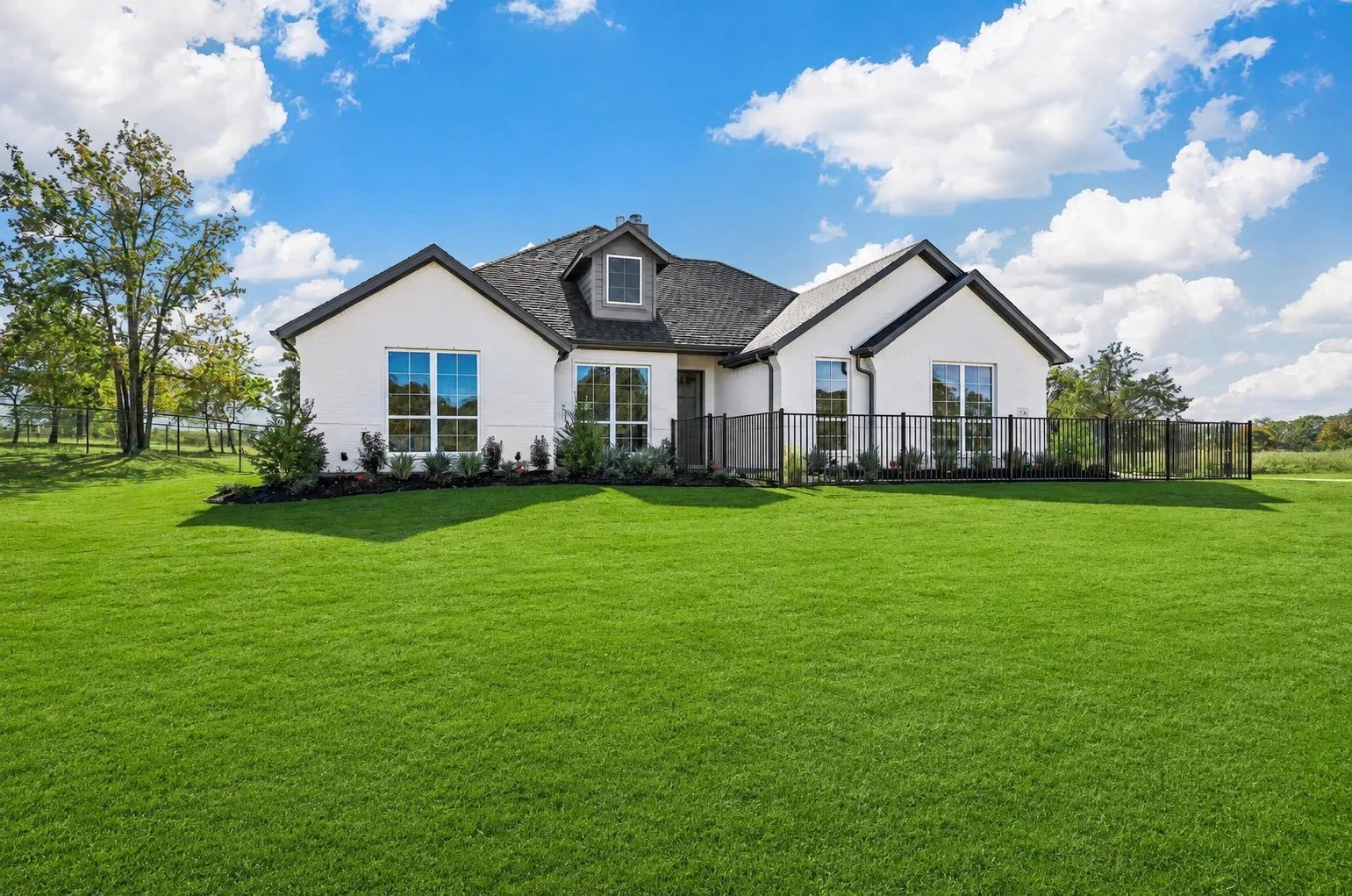 White stucco exterior with black trim and a dark shingle roof