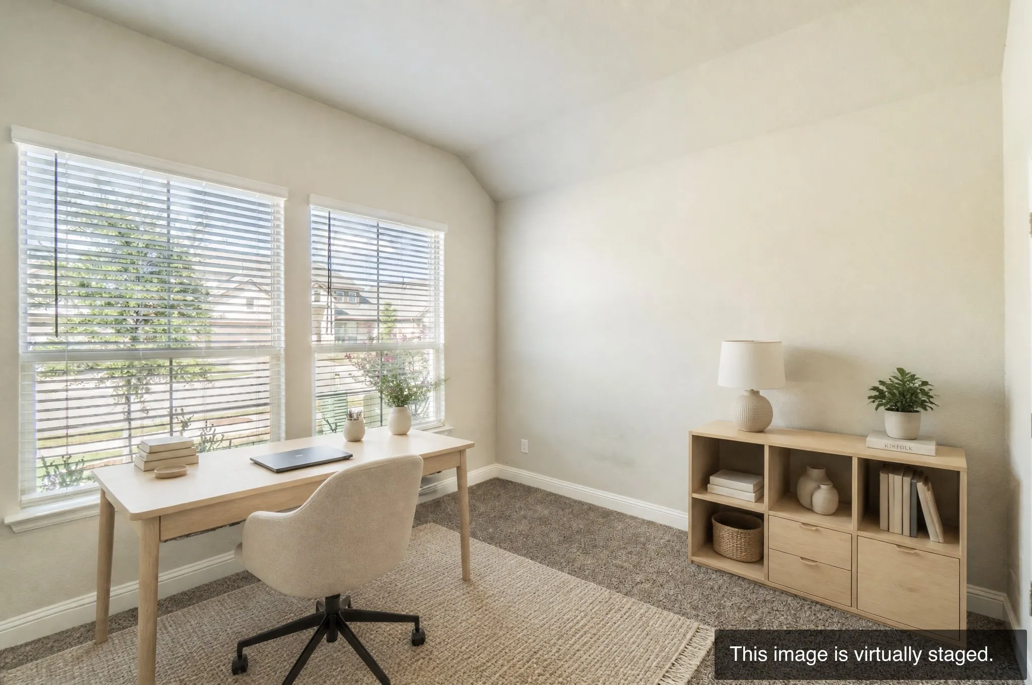 Dual windows providing ambient light, vaulted ceiling, and neutral wall tones