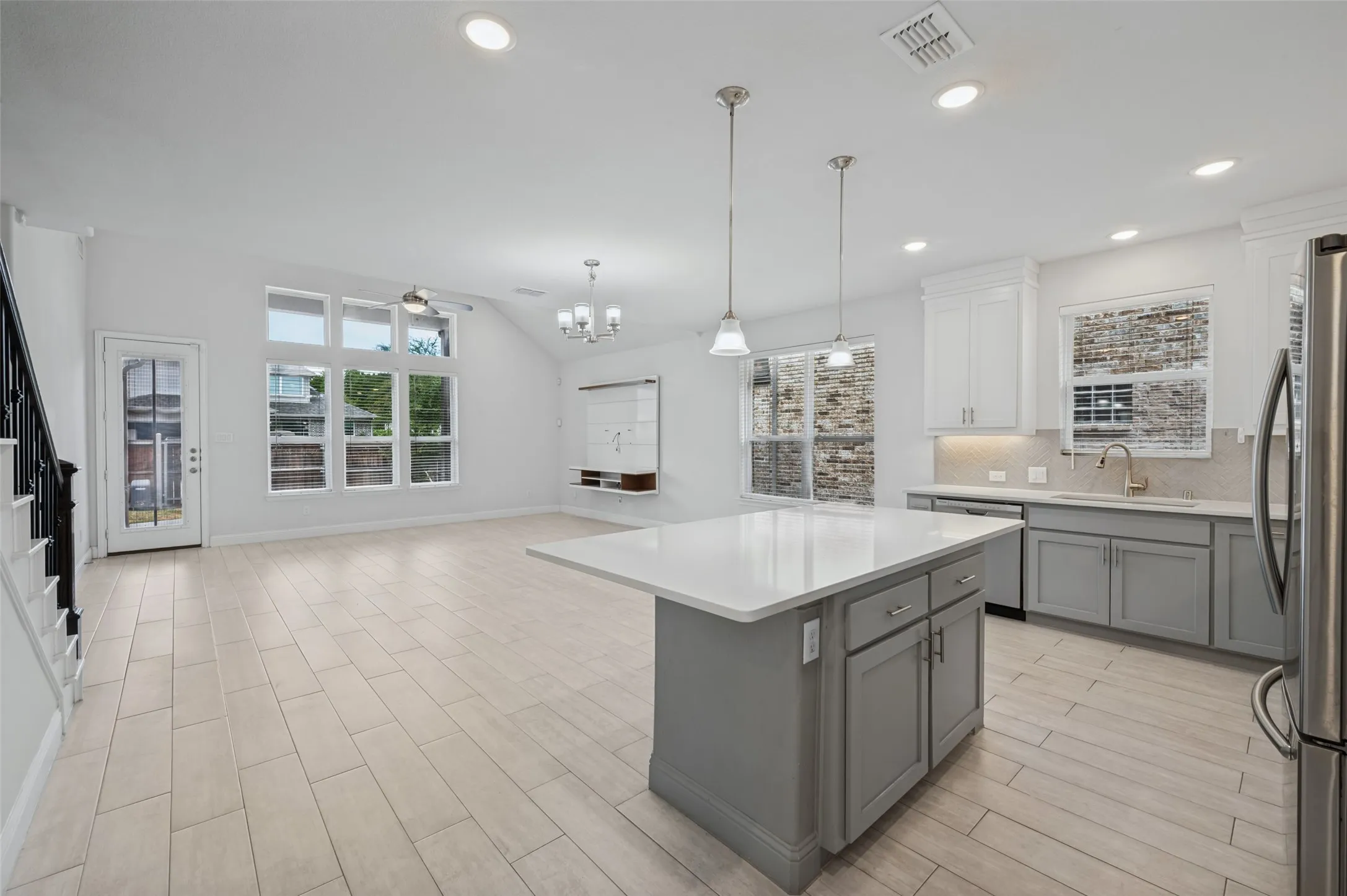 View from kitchen to dining area and into living area. Full view of spacious backyard.