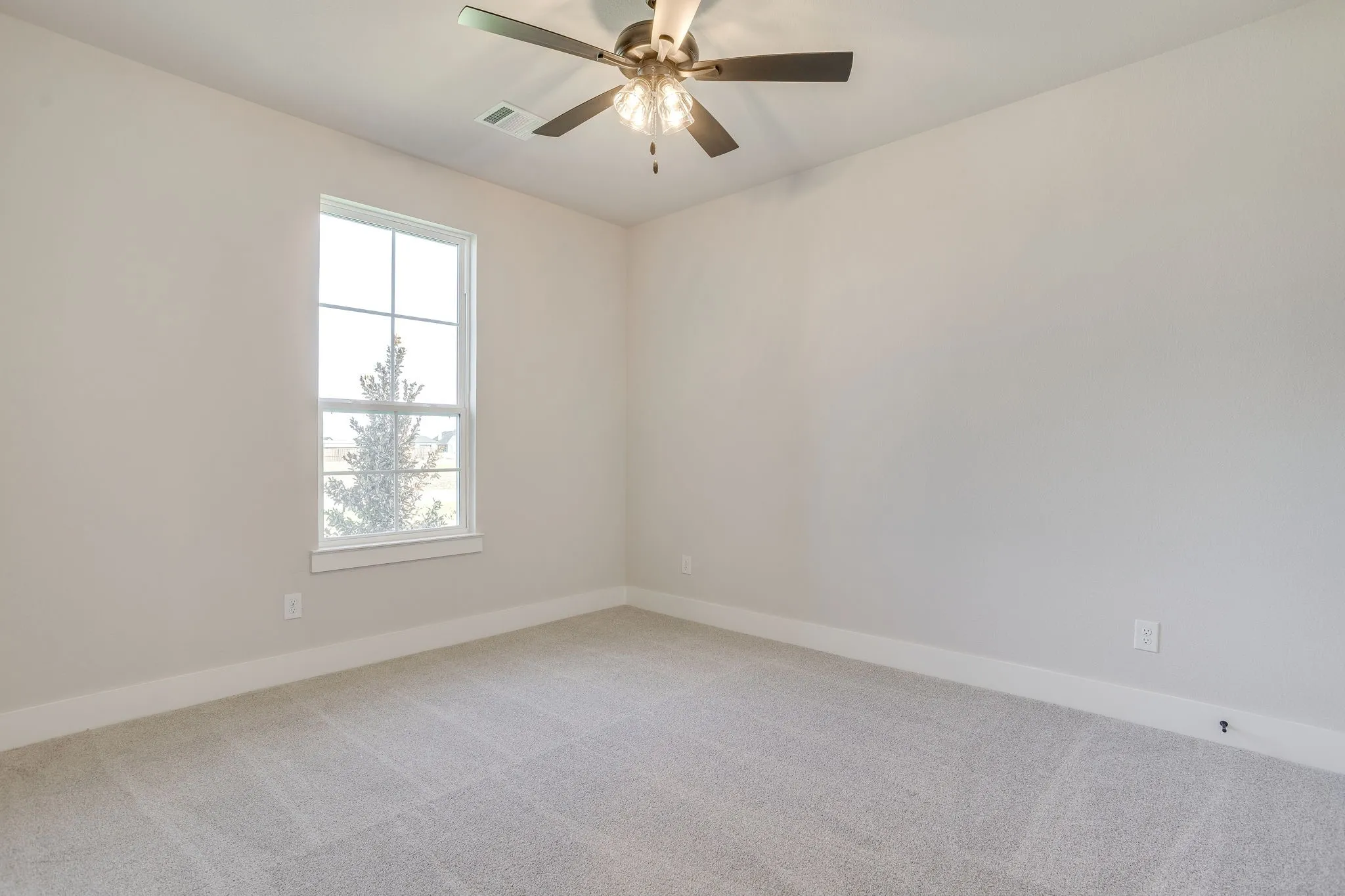 Recessed lighting, ceiling fan, neutral wall color, carpet flooring, and a large window