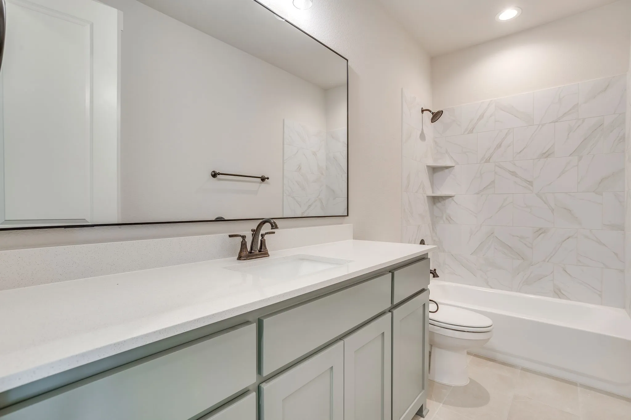 Vanity with light-toned countertop, integrated sink, and bronze-finish faucet