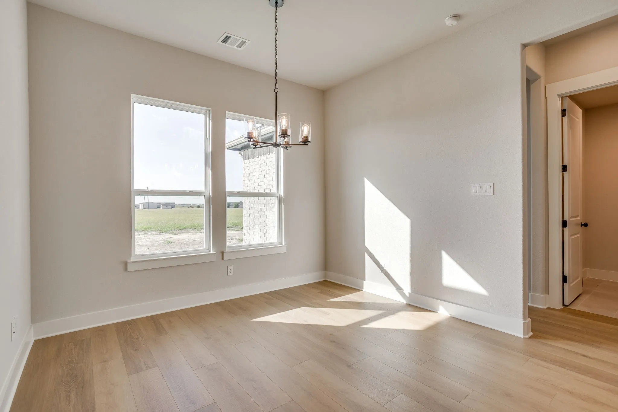 Recessed ceiling, wood-finish flooring, and a contemporary chandelier