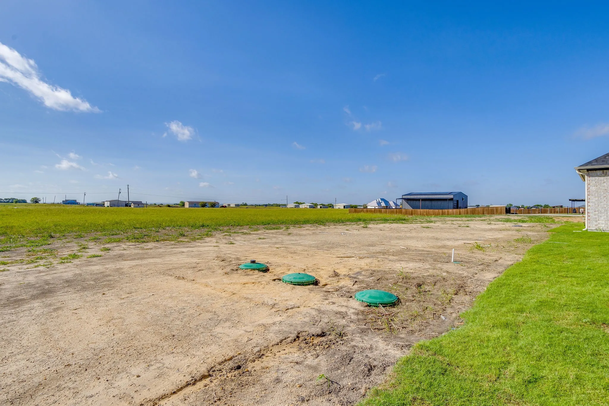 Expansive land parcel with installed ground features and partial manicured lawn