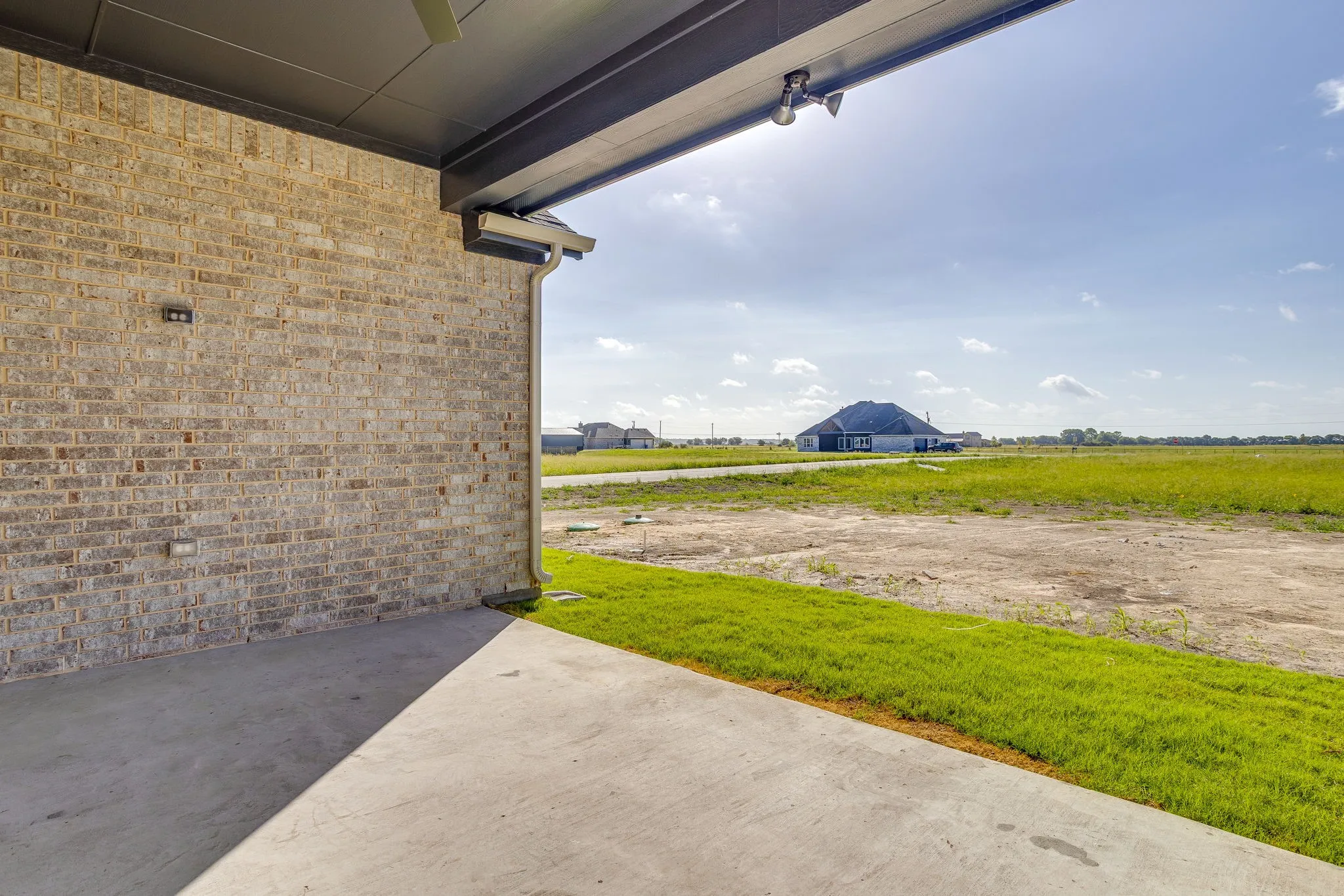Covered concrete patio with recessed lighting and a ceiling fan