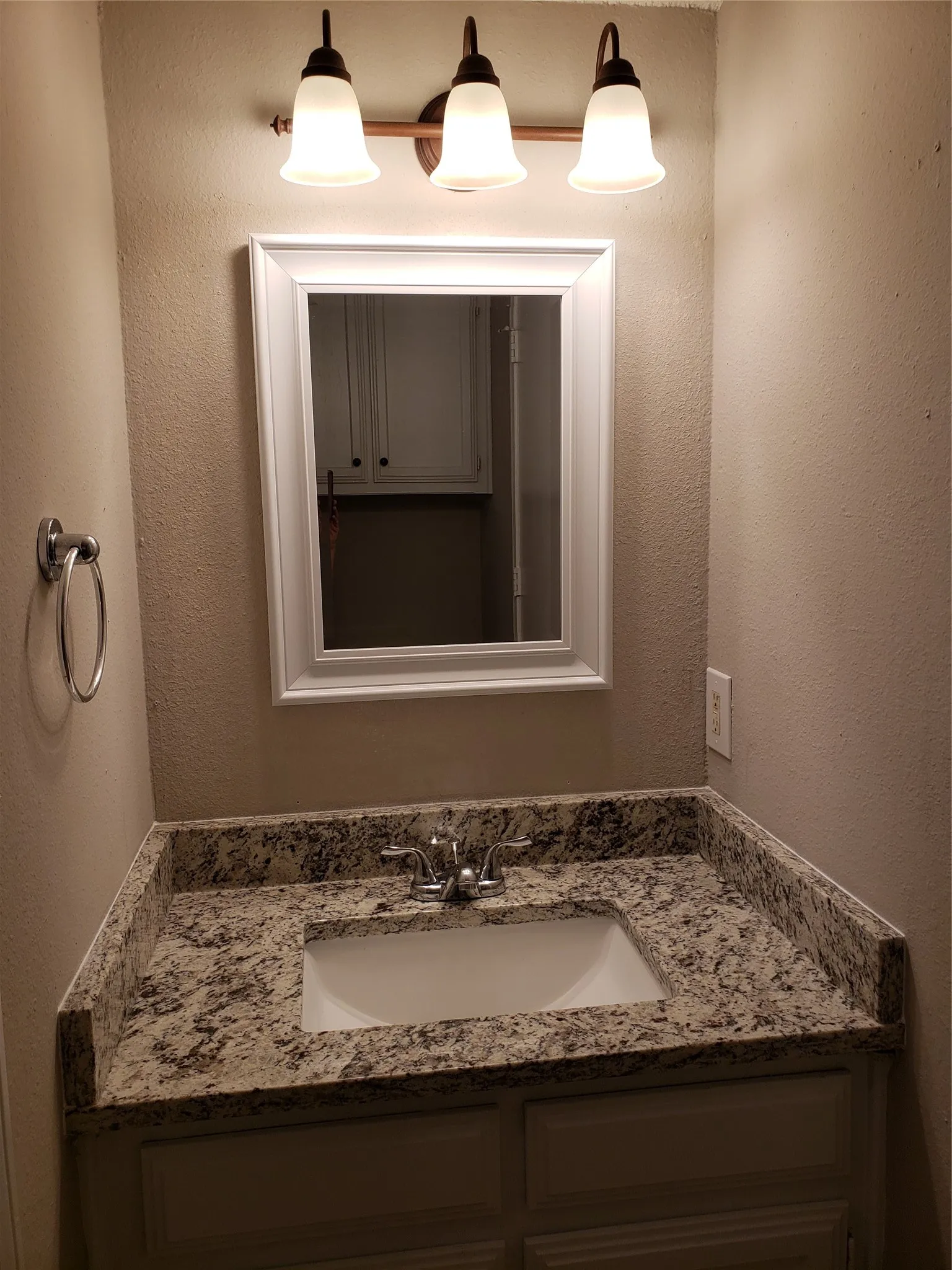 808 - Downstairs vanity, sink, mirror, across from toilet; walkthrough to utility area.