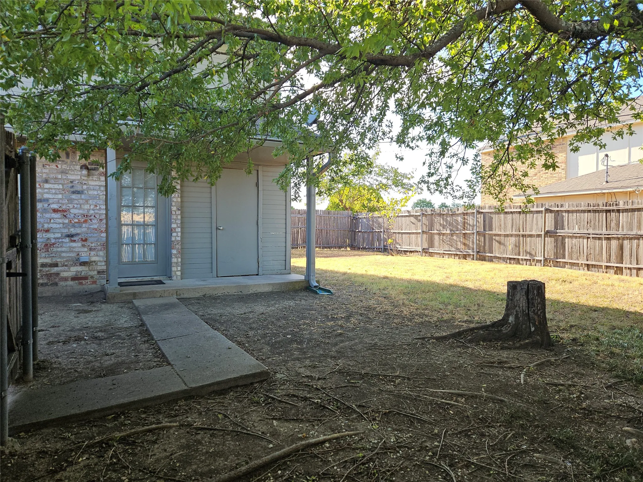 810 - Fenced yard and back porch with storage closet.