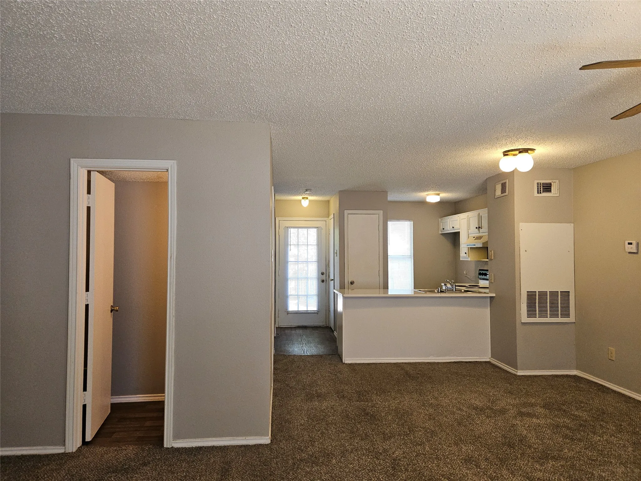 810 Downstairs half-bath across from entry, view of dining area, back door, and kitchen countertop bar.