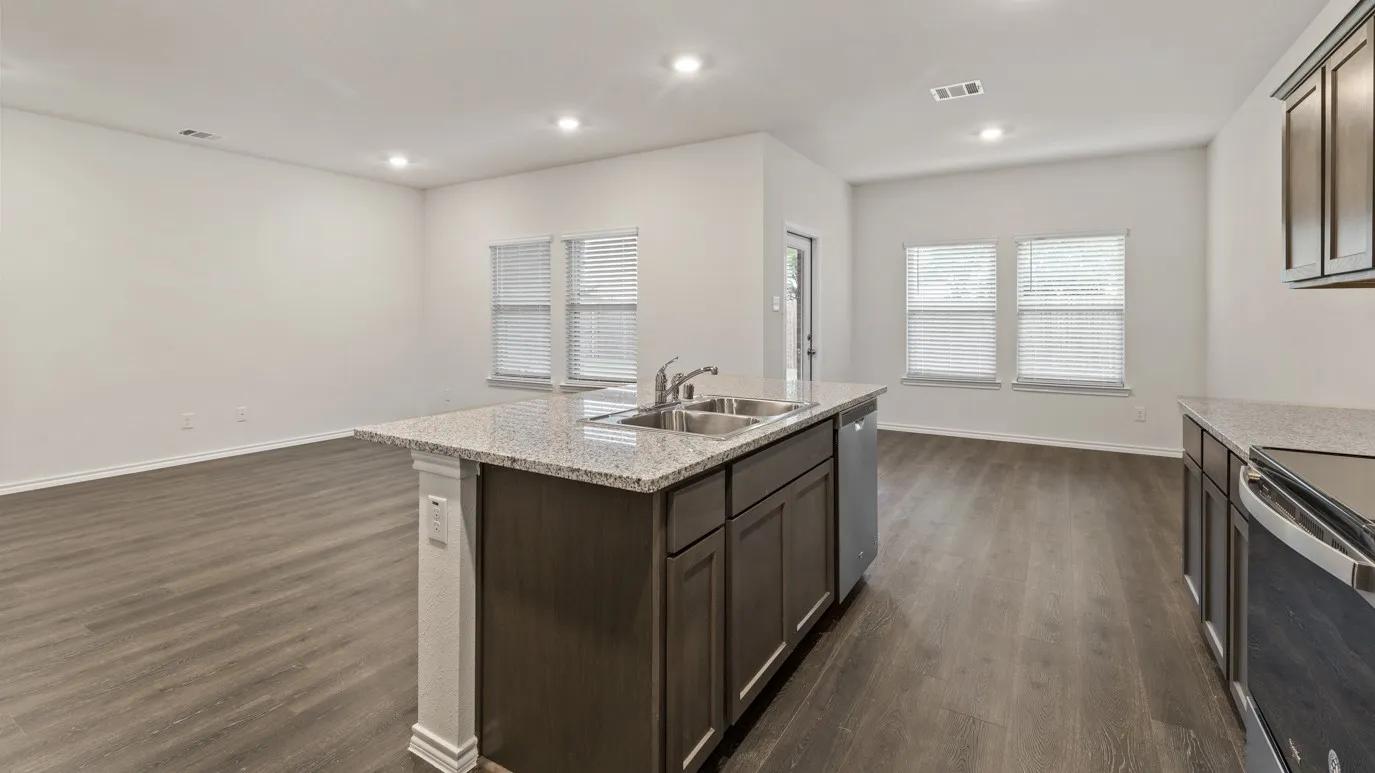 Open-concept living space featuring wood-finish flooring, recessed lighting, and multiple windows