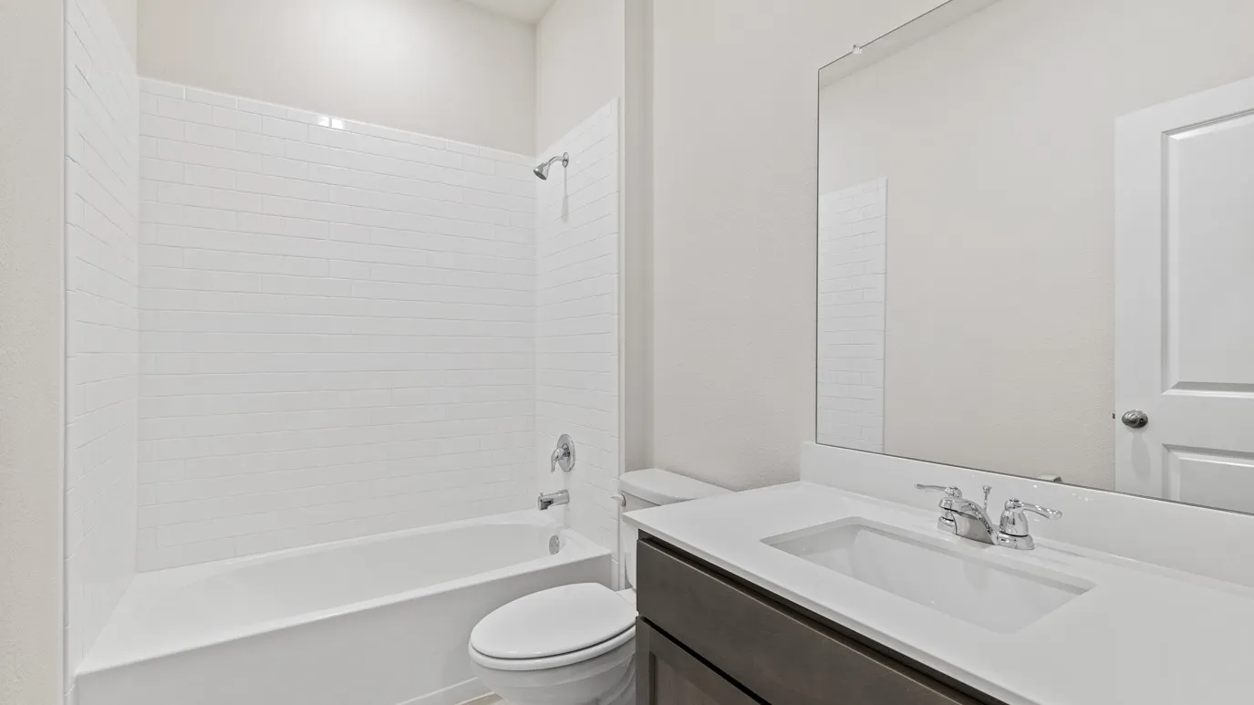 Tub and shower combination with subway tile surround, single vanity with integrated sink, chrome fixtures, and a large mirror