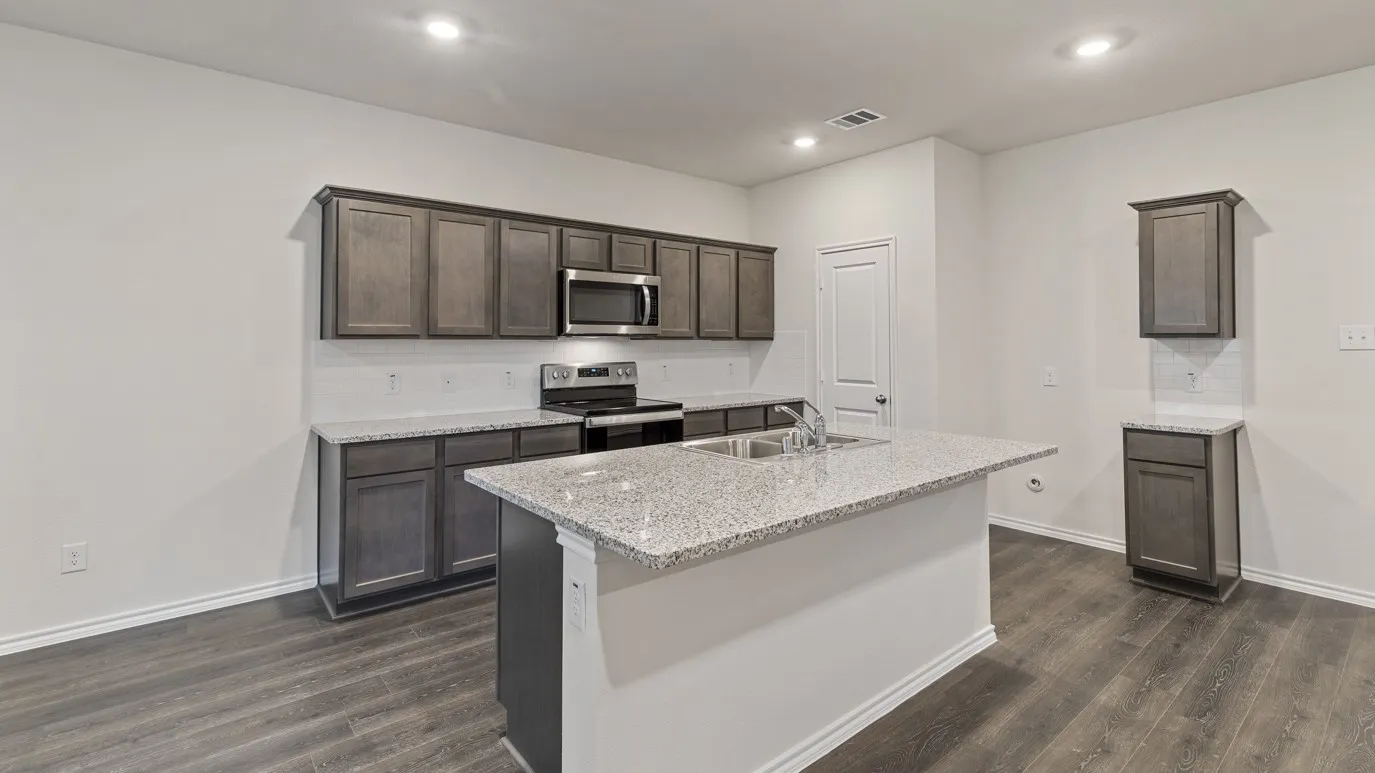 Kitchen featuring wood-finish flooring, recessed lighting, dark wood cabinetry, light-colored countertops, and stainless steel appliances
