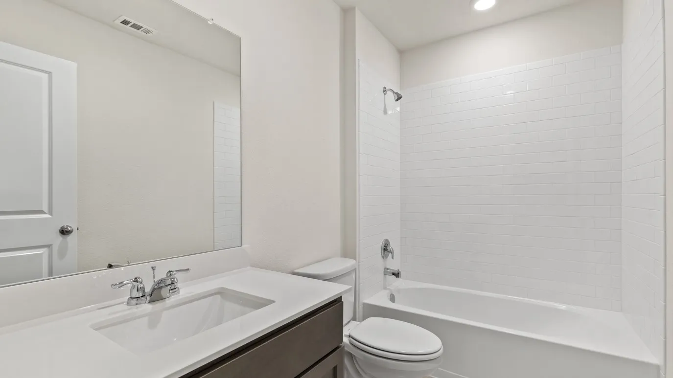 White subway tile shower surround with chrome fixtures, integrated bathtub, and a modern vanity with an undermount sink and chrome faucet