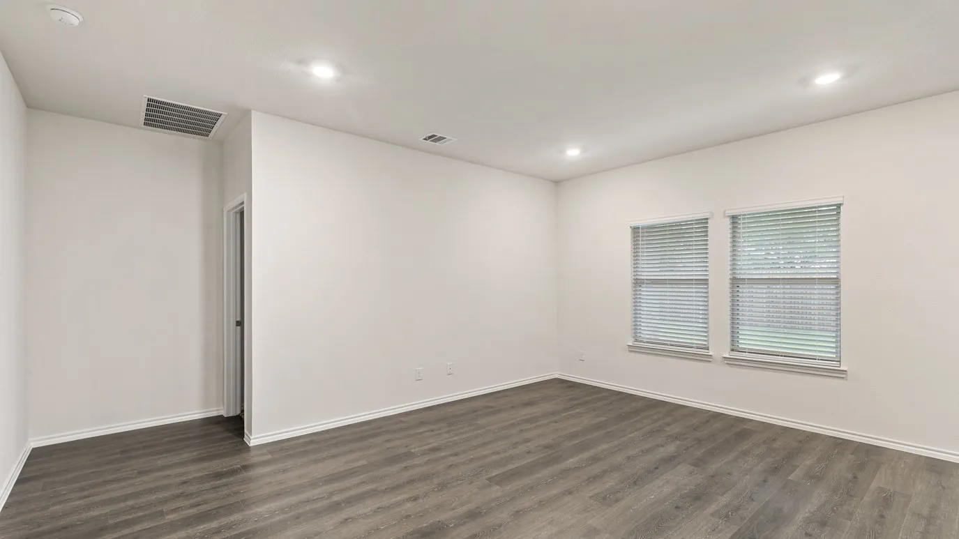 White walls, recessed lighting, wood-finish flooring, two windows with blinds, and white trim