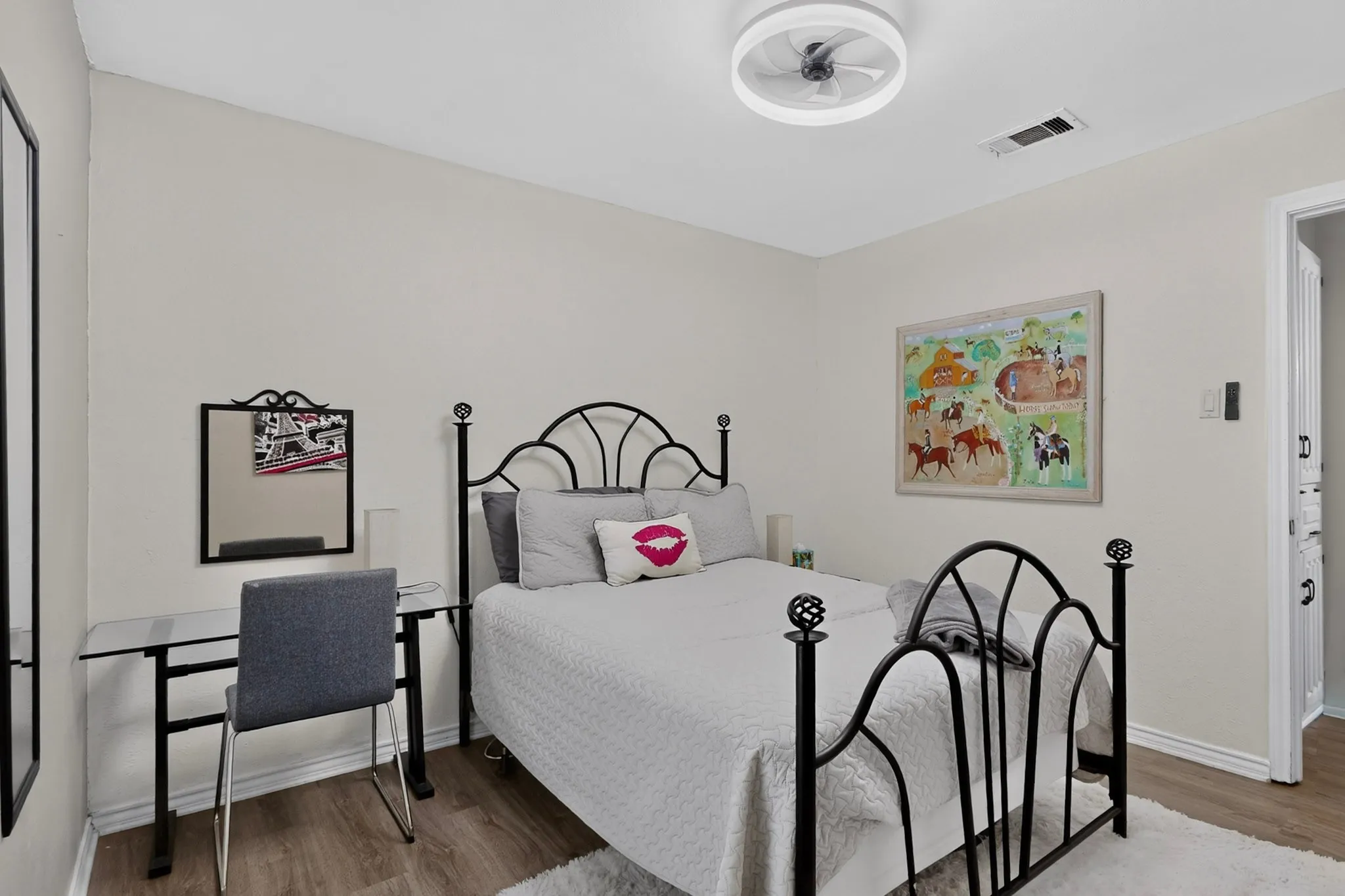 Wood-finish flooring with white baseboards, a white ceiling with a contemporary ceiling fan, and white painted walls