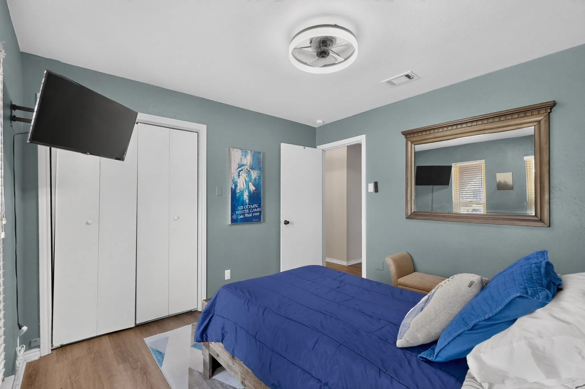 Wood-finish flooring throughout, a modern ceiling fan, and bi-fold closet doors