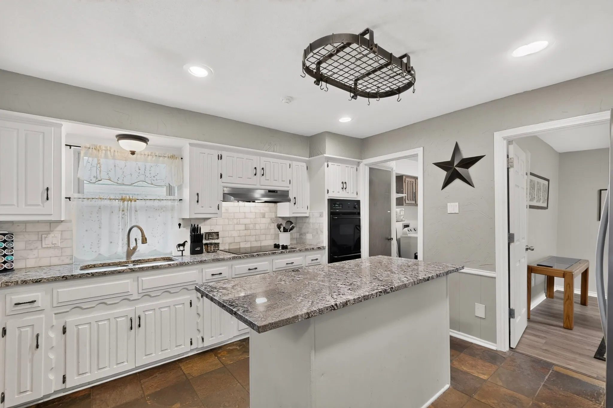 Kitchen featuring white cabinetry, a built-in oven, a center island with a stone countertop, a tile backsplash, and recessed lighting